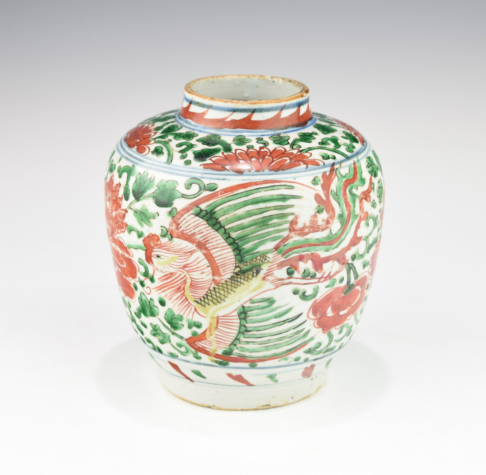 A SHUNZHI PERIOD CHINESE FAMLLE VERTE BLAUSTER JAR: 17th century. Decorated with two phoenixes amidst scrolling lotus in famille verte enamel. Condition: some scratches on the iron-red enamel, old minor chips to the foot rim. Height:17.3 CM.