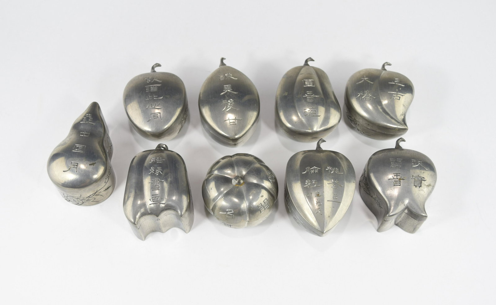 NINE RARE 19TH CENTURY CHINESE TIN WINE WARMING SETS: Each set has a wine cup and a warming box in a shape of assorted fruits, decorated with auspicious words, flowers or orchids, great condition without damages or restorations. Dimension: boxes Length 6