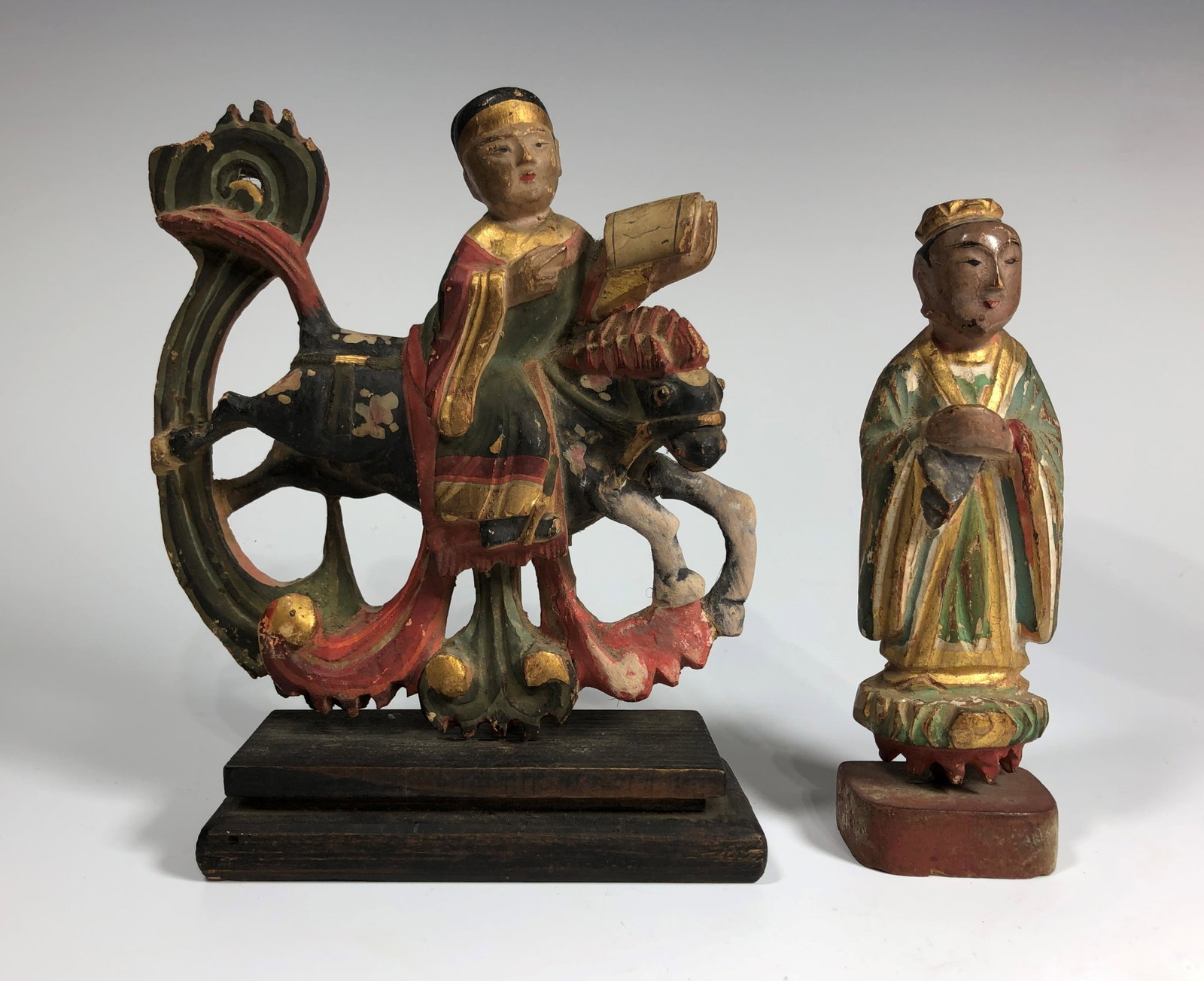 TWO CHINESE MING DYNASTY WOODEN FIGURINES: Carved and painted, one depicting a man holding a book on a horse back. Overall good condition commensurate with age. Size of the largest: 14 CM H x 12 CM W