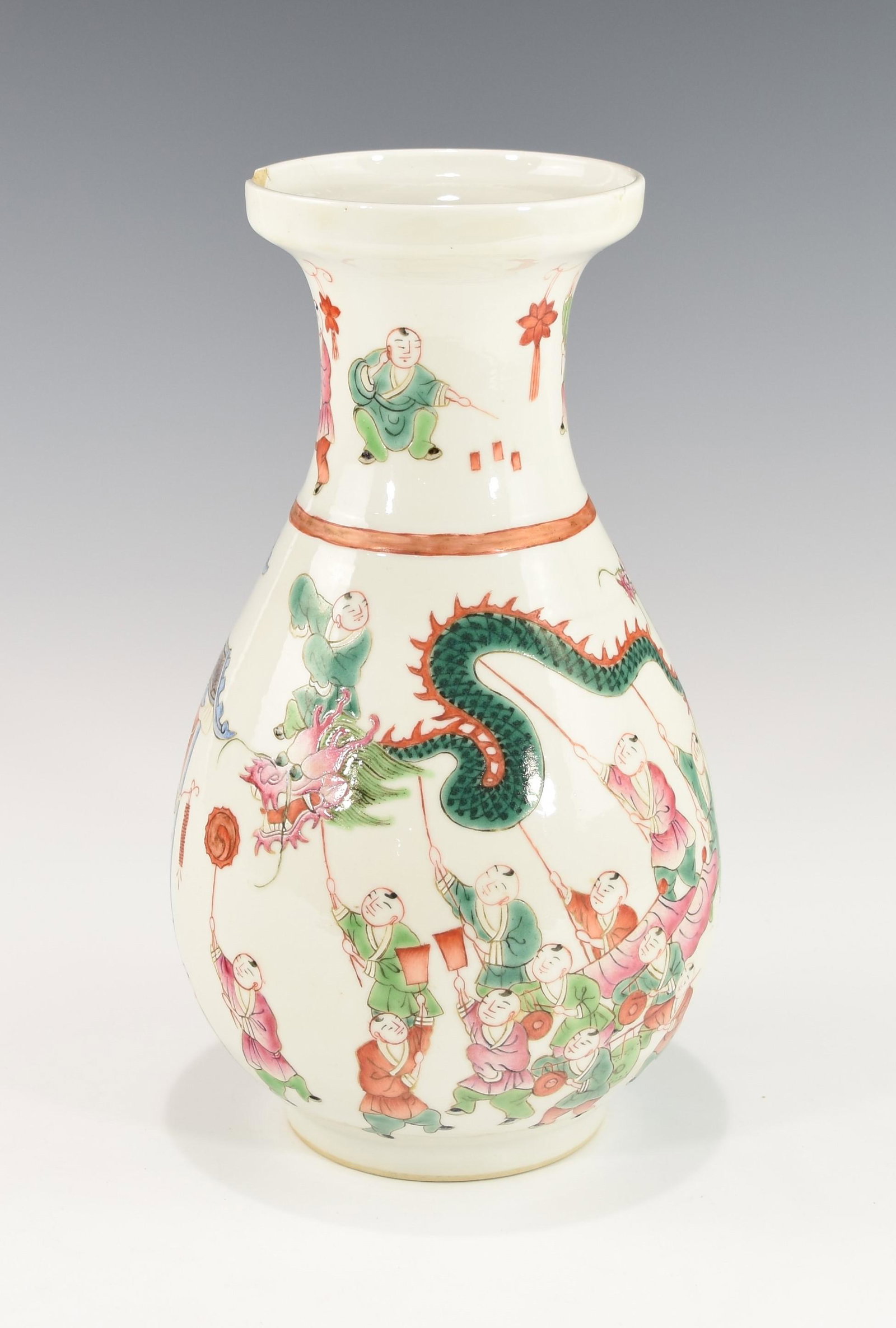 ONE 19TH CENTURY CHINESE FAMILLE ROSE DRAGON DANCE VASE: Pear-shaped body, depicting boys in a procession performing a dragon dance, playing instruments, setting off fireworks and holding lanterns. The mouth has a chip and a short tight hairline, otherwise 