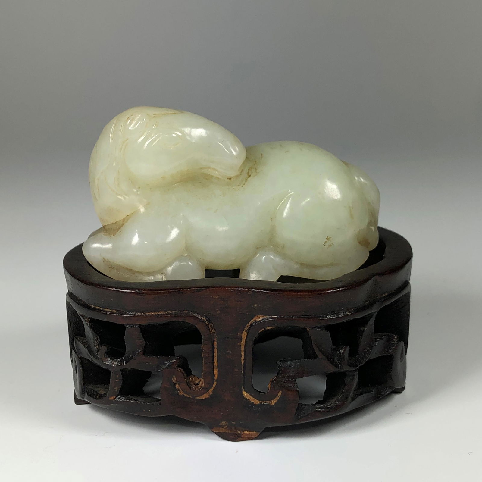 AN 18TH CENTURY CHINESE PALE CELADON JADE HORSE: With rosewood stand. Good condition. 5.5 CM Lg x 3 CM D, Wt 50 gm