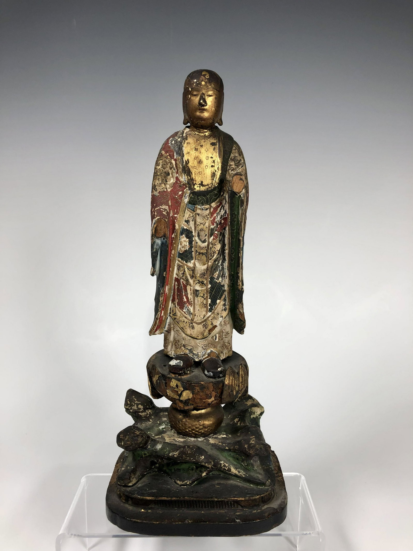 A CHINESE MING DYNASTY GILT AND PAINTED WOOD LUOHAN: Standing on a rock shaped base, with nicely aged patina, both hands missing, otherwise in fair good condition consistent with age. Please refer to the photos for more details. Size: 24 CM H x 10.5 CM 