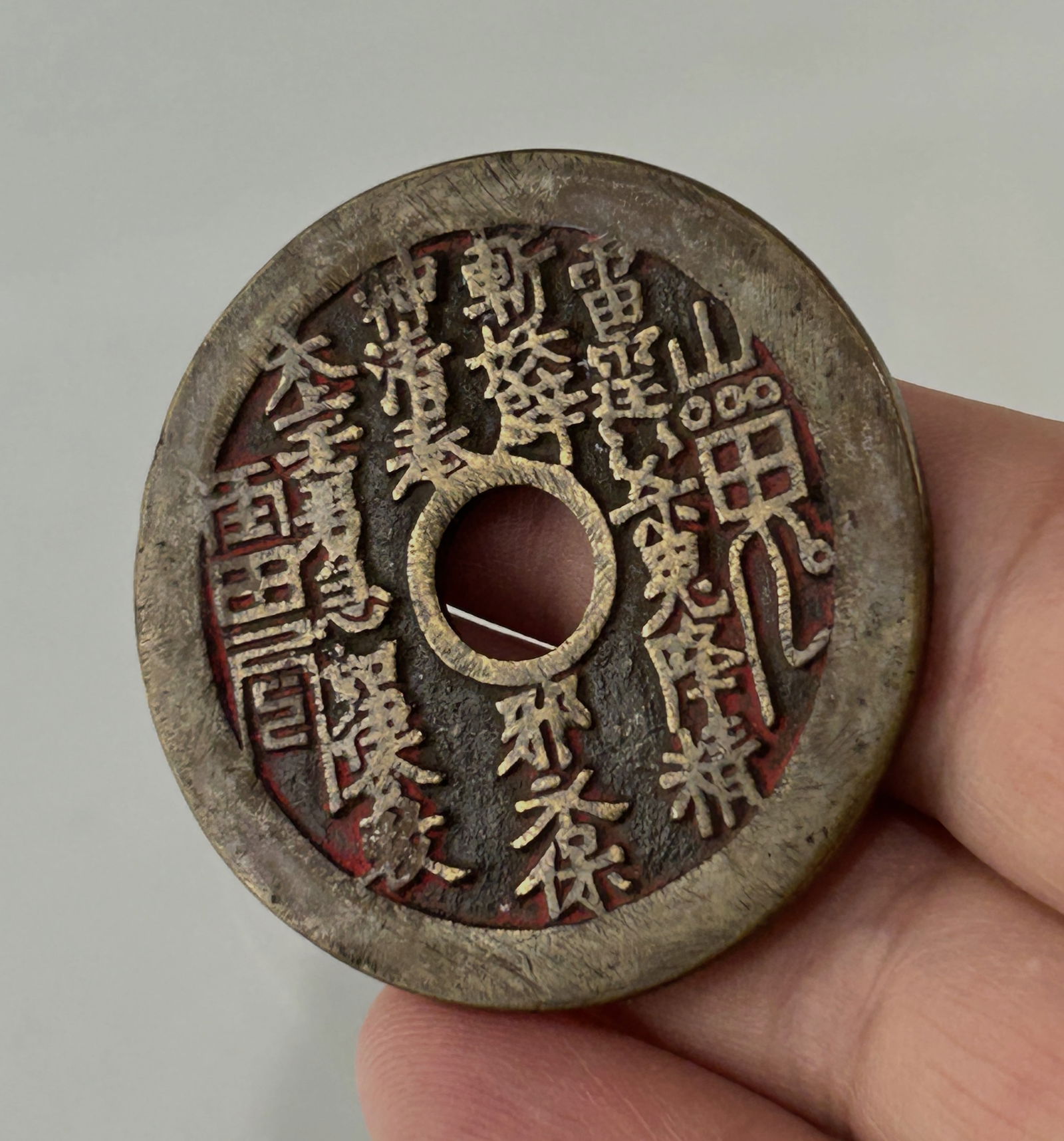 A CHINESE ANTIQUE MOUNTAIN GHOST DAOIST COPPER COIN CHARM, 19TH CENTURY: One side incised with both Daoist magical characters and normal Chinese characters. The other side with Yin-Yang Eight Trigrams, a Daoist and a Daoist magic character. In good vintage condition with r