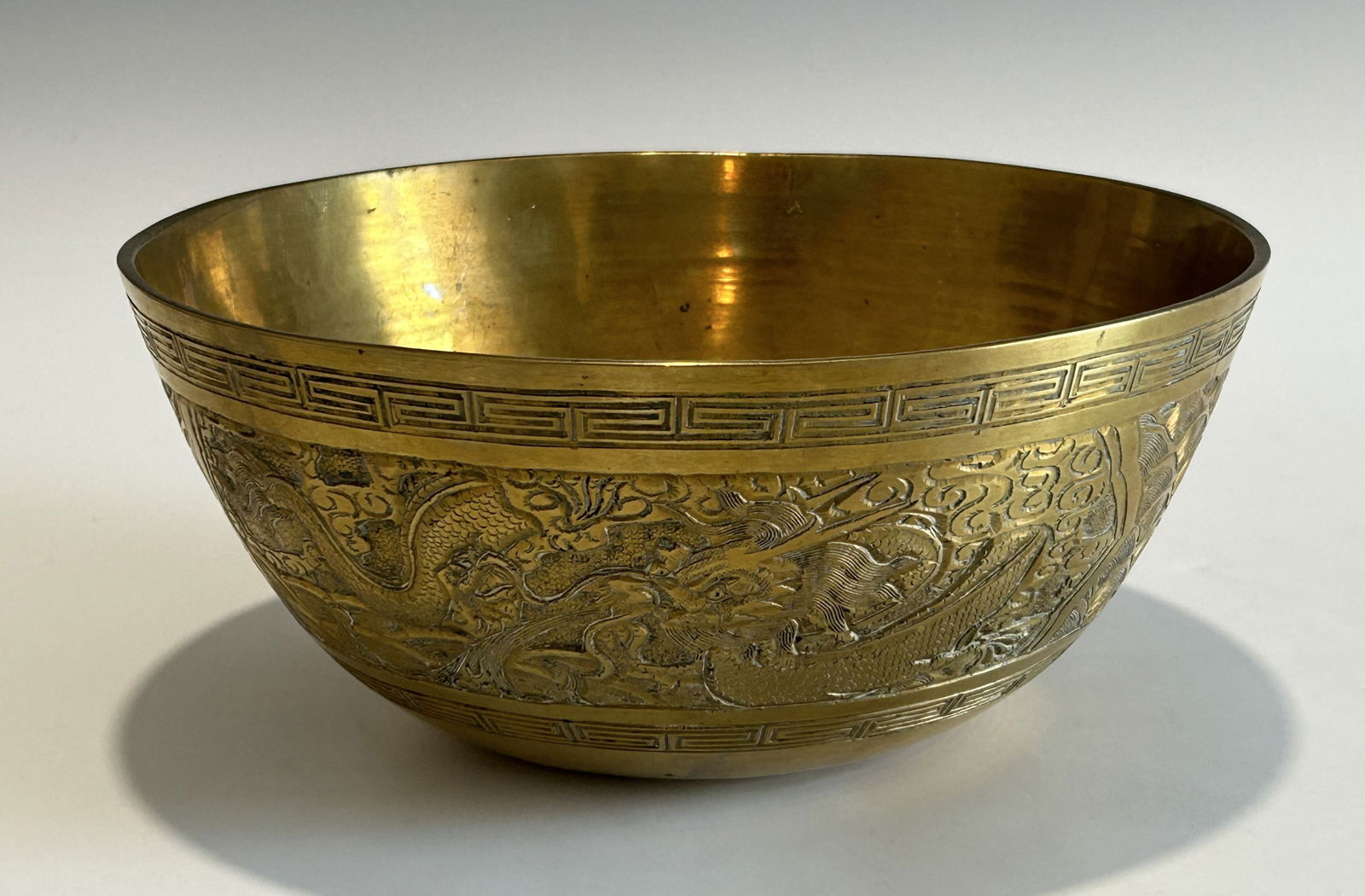 A CHINESE QING DYNASTY FINELY CARVED DRAGON AND PHOENIX BRASS BOWL, EARLY 19TH CENTURY (1 of 11)