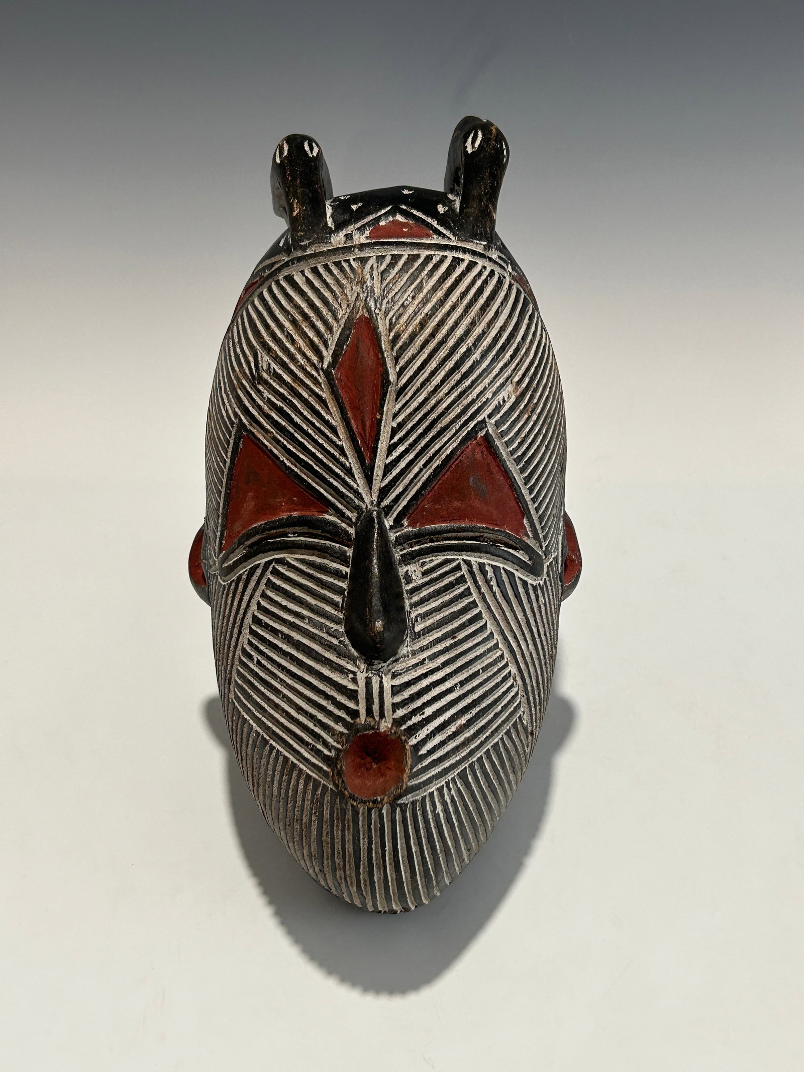 A TRADITIONAL AFRICAN SONGYE WOODEN CEREMONIAL MASK: A mid-19th to early 20th century piece. Well-carved, decorated with Ochre pigments. In very good vintage condition with aged patina, signs of use and wear. Please refer to the photos for more details.