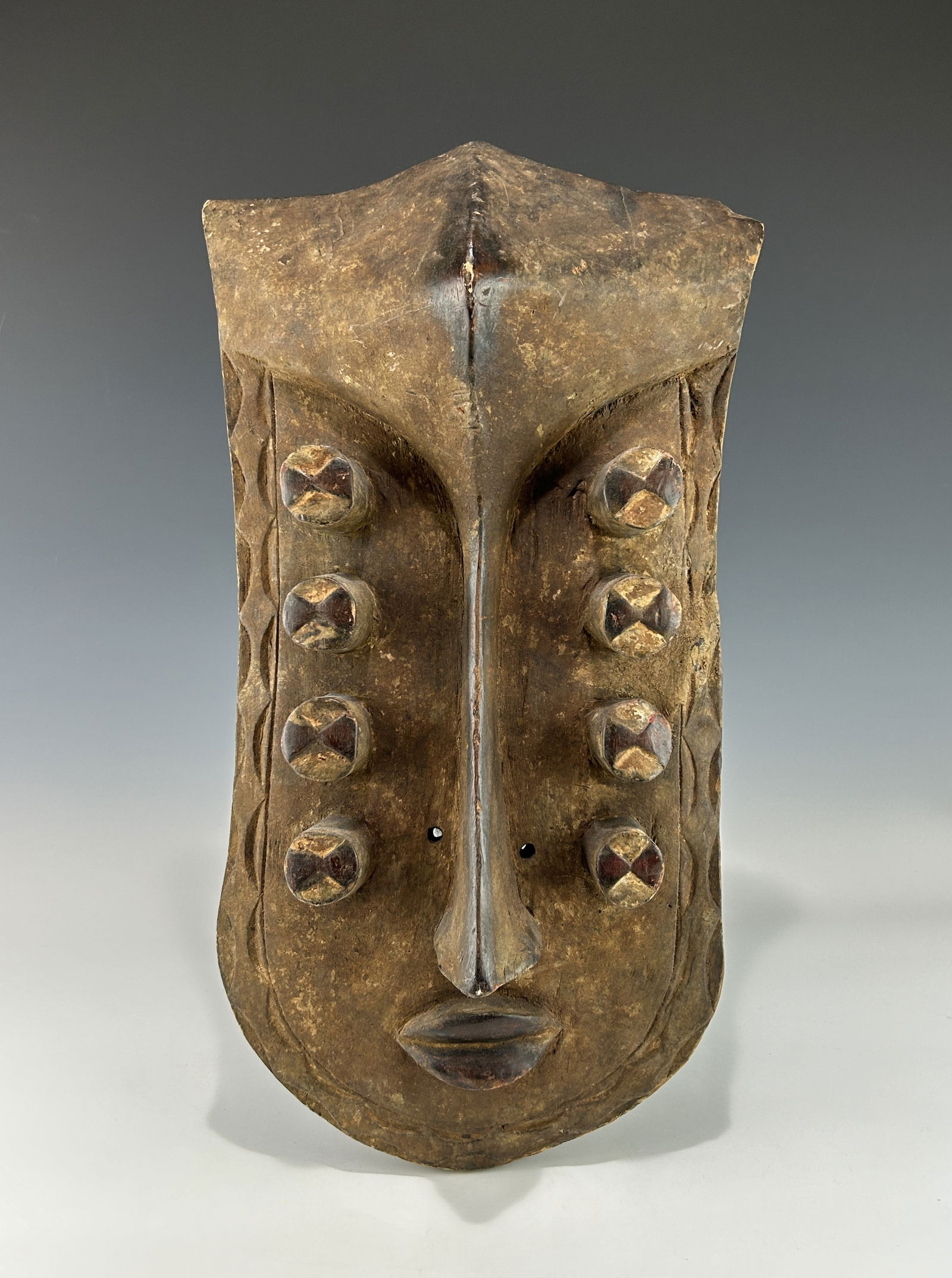 A LARGE TRADITIONAL AFRICAN IVORY COAST OR LIBERIA GREBO WOODEN MASK WITH EIGHT TUBULAR EYES (1 of 7)