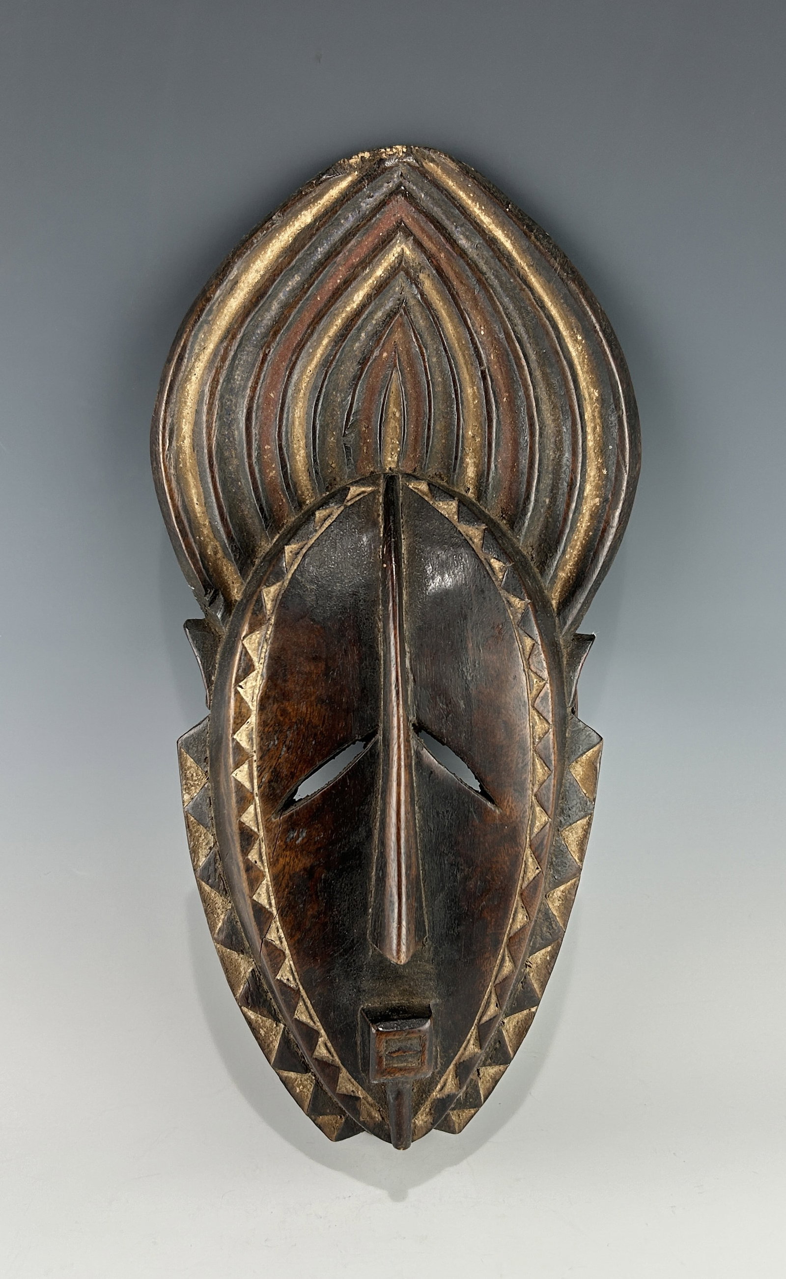 A TRADITIONAL AFRICAN IVORY COAST/GHANA KOULANGO WOODEN MASK: A mid-19th to early 20th century piece. Well carved and decorated with brown, black and white Ochre pigments. In very good vintage condition with aged patina, signs of use and wear. Please refer to th
