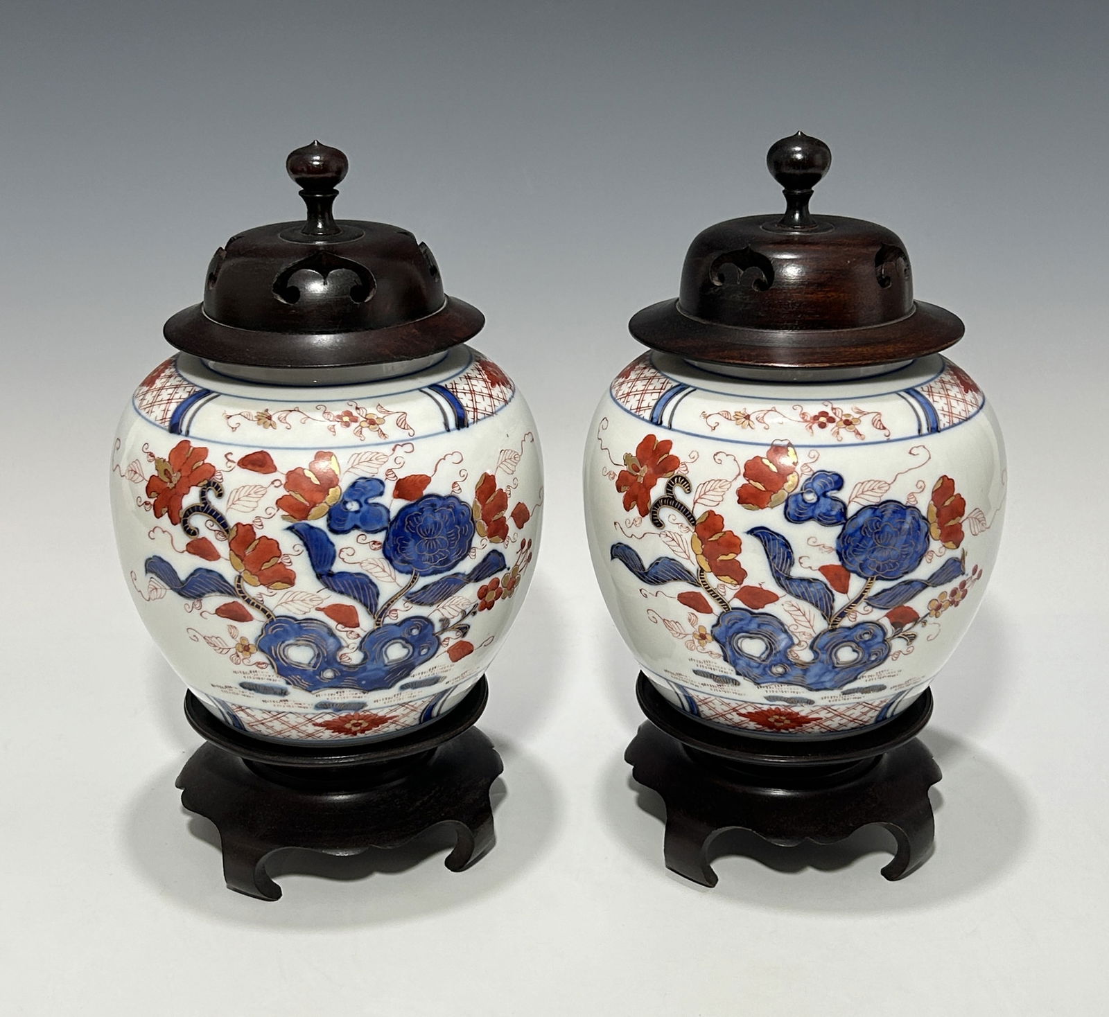 A PAIR OF JAPANESE OLD IMARI PORCELAIN JARS WITH CARVED HARDWOOD LIDS AND STANDS (1 of 5)