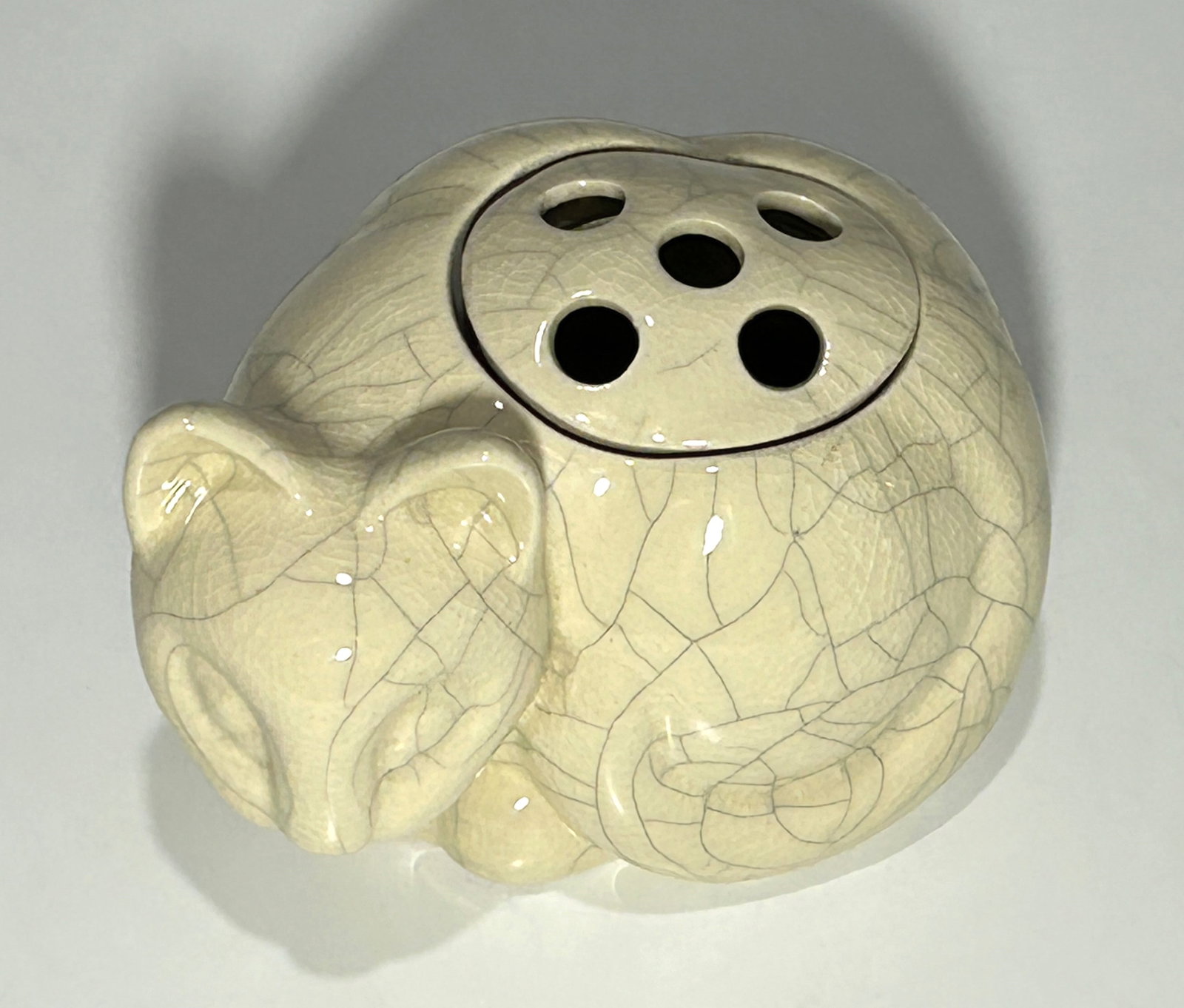 TIFFANY & CO. 1978 CRACKLE GLAZE CERAMIC CAT FLOWER HOLDER: This is a delightful vintage ceramic flower holder by Tiffany & Co., dated 1978. Crafted in the shape of a curled-up cat, it features a soft cream-colored crackle glaze finish. The piece includes a re