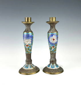 PAIR OF ANTIQUE JAPANESE CLOISONNÉ CHAMPLEVE CANDLESTICKS: A finely crafted pair of Japanese Meiji-era cloisonné enamel candlesticks, each with a brass core and cup holder. The baluster-shaped bodies feature stylized chrysanthemum blossoms in vivid blue, whi