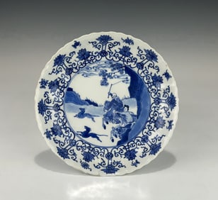 CHINESE KANGXI (1662–1722) BLUE AND WHITE SCALLOP RIM PORCELAIN ‘HUNTING SCENE’ PLATE