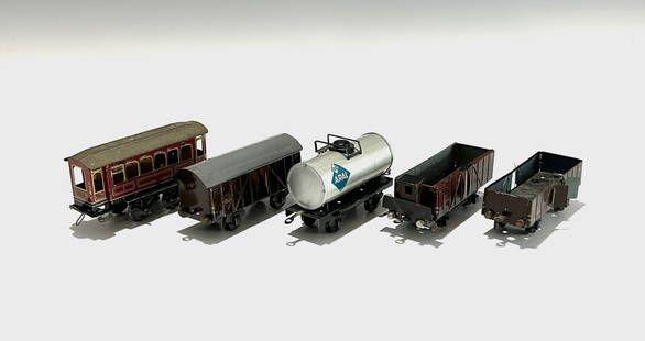 FIVE EARLY PRE-WAR TRAIN CARS: Including a charming burgundy passenger carriage with lithographed window details, a brown covered goods wagon, a silver "ARAL" fuel tanker, and two brown open freight cars. Each piece features metal