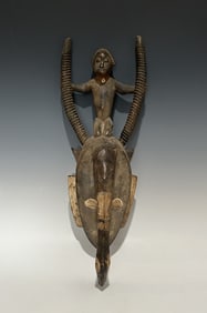 IVORY COAST DJIMINI MASK WITH FEMALE FACE AND FIGURAL SURMOUNT, MID-CENTURY OR EARLIER