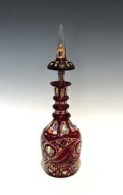 BOHEMIAN RUBY OVERLAY, GILT, AND ENAMELED CUT GLASS DECANTER WITH STOPPER