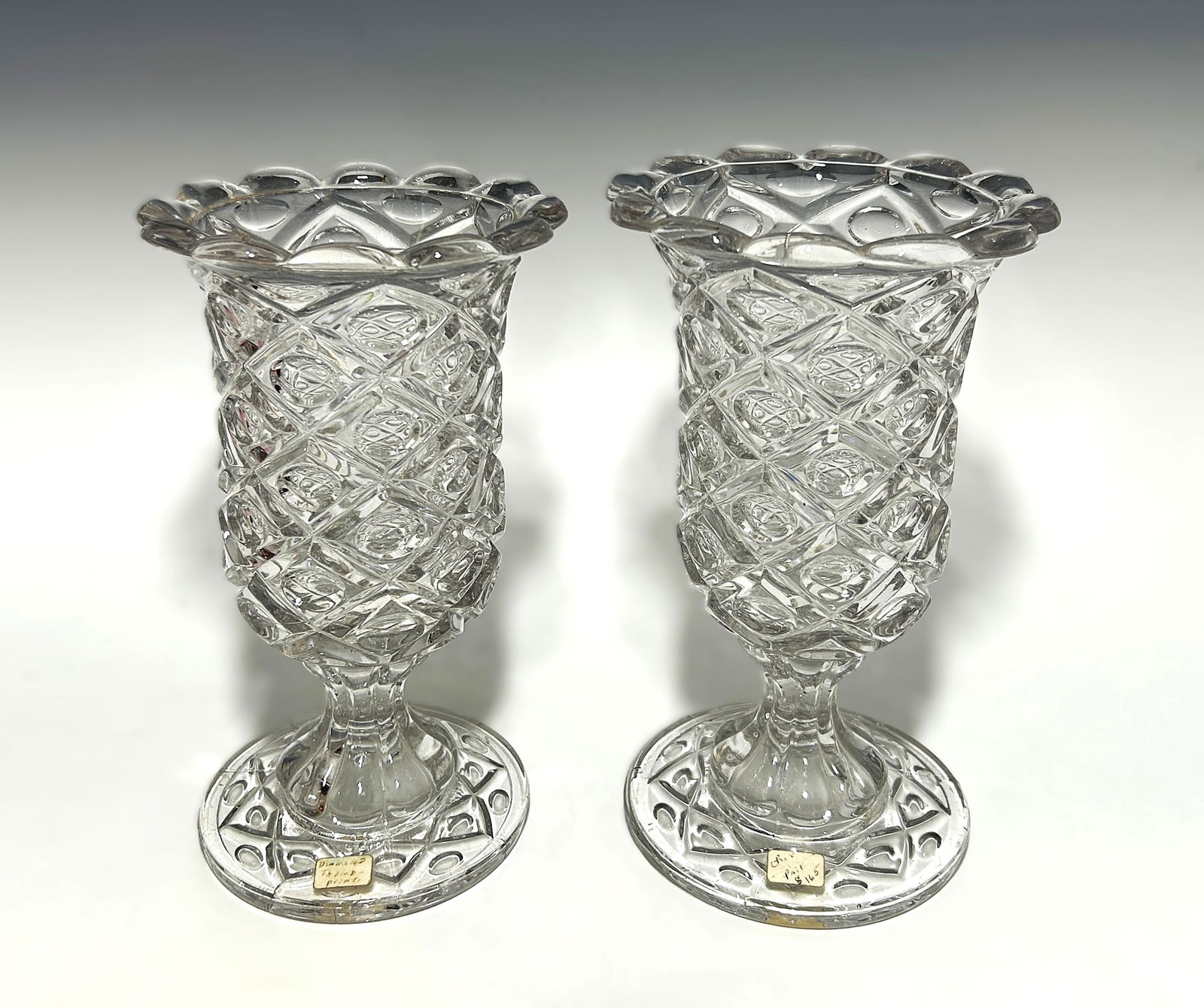 PAIR OF MUSEUM QUALITY ANTIQUE AMERICAN DIAMOND THUMBPRINT PATTERN PRESSED FLINT GLASS CELERY VASES: Circa 1850s, each vase featuring the classic “Diamond Thumbprint” pattern with repeating diamond panels enclosing a concave oval, a highly decorative Victorian design. Both have scalloped rims