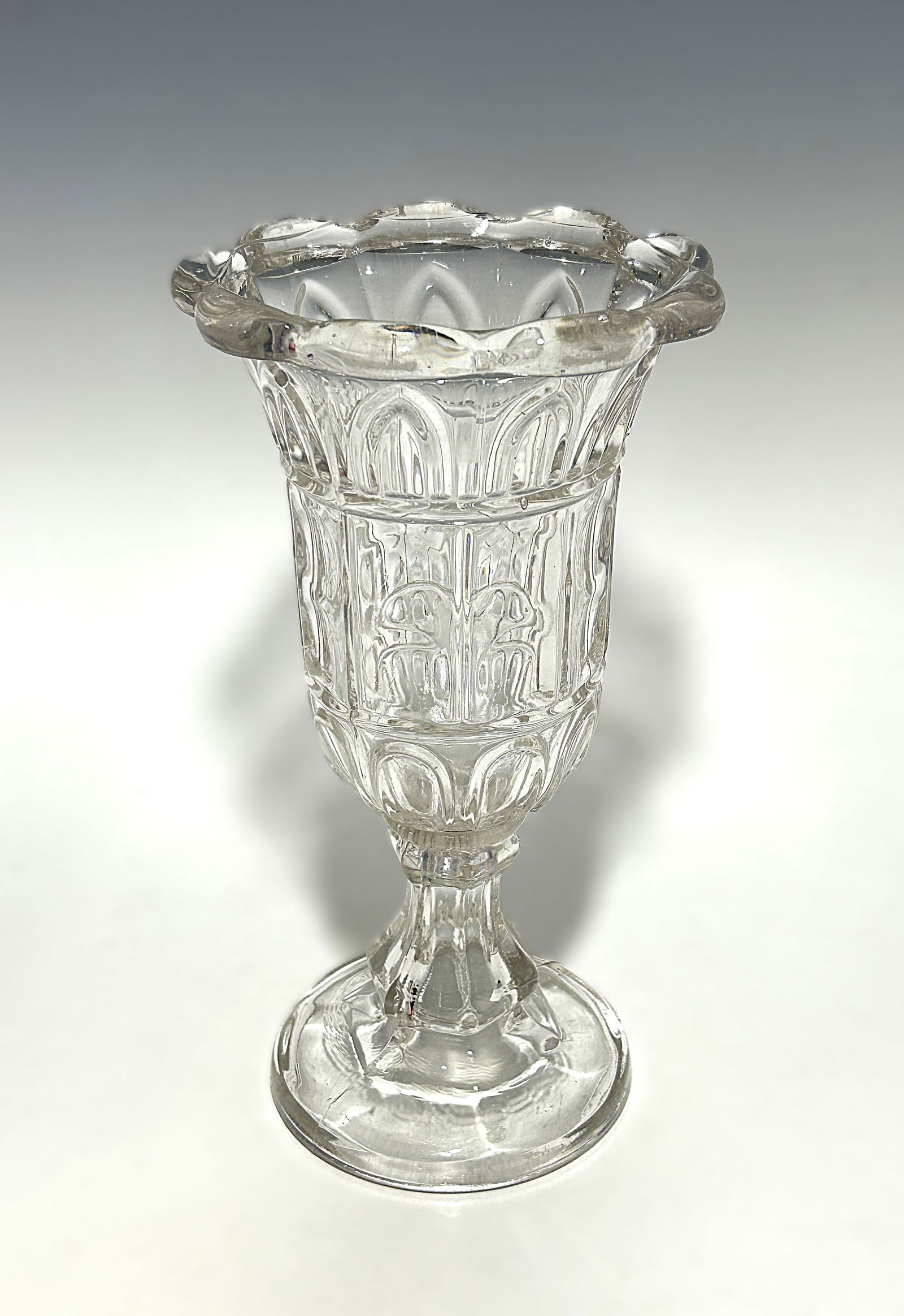 MUSEUM QUALITY EAPG PUNTY & GOTHIC ARCH PATTERN FLINT GLASS CELERY VASE: Circa 1850s, Early American Pattern Glass (EAPG) celery vase in clear flint glass, featuring a repeating Gothic arch panel design to the body and a scalloped rim with applied punty-style detail. Raise