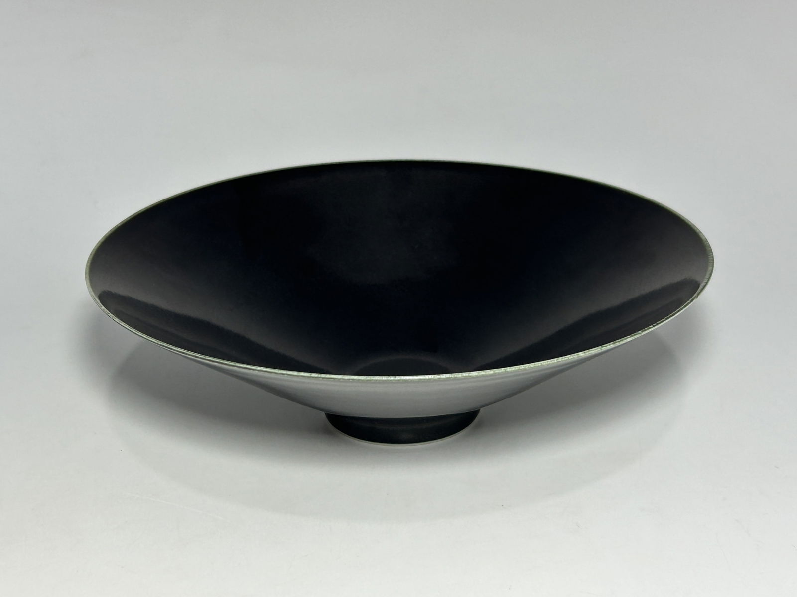 ORIENTAL DARK GREY GLAZE EGG-SHELL PORCELAIN CONICAL BOWL: Of wide flaring form, exceptionally thinly potted. Uniform dark grey to near-black glaze applied inside and out. A subtle greenish hue visible along the mouth rim and near the exterior of the foot rim