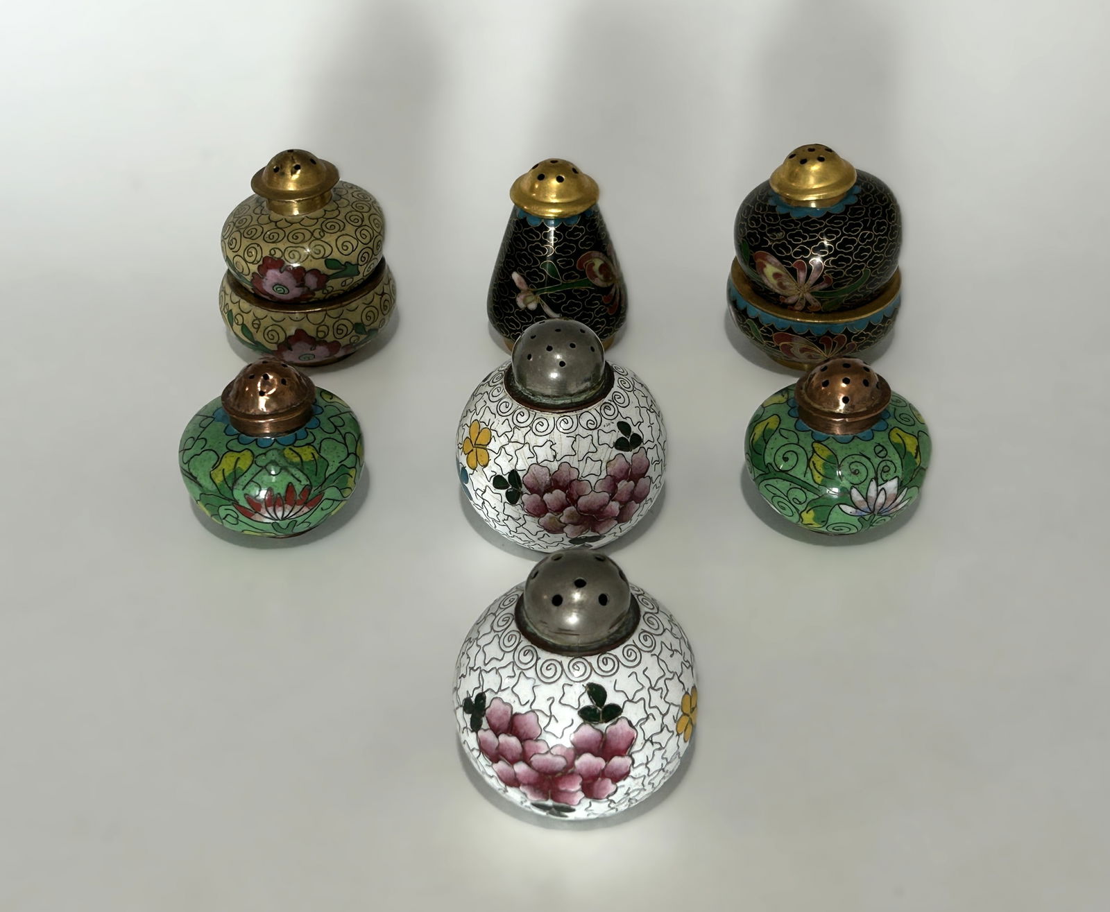 GROUP OF VINTAGE CHINESE CLOISONNÉ SALT AND PEPPER SHAKERS: Decorative group of vintage Chinese cloisonné salt and pepper shaker table wares, comprising multiple matched and complementary pairs in rounded, baluster, and double-gourd forms. The group represent