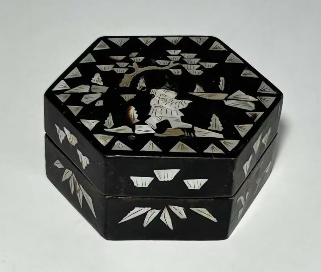ANTIQUE CHINESE MOTHER-OF-PEARL INLAID LACQUER HEXAGONAL BOX: Dating to the late Qing Dynasty or early Republic period, finely decorated with mother-of-pearl inlay against a deep black ground. The lid is centered with a figural scene depicting a scholar or atten