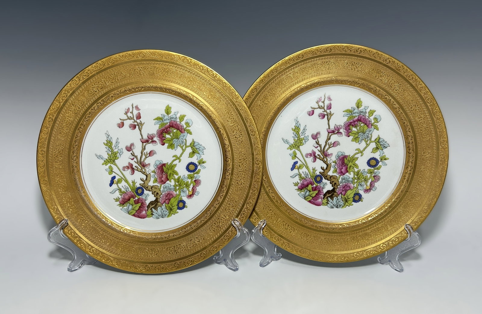 PAIR OF HEINRICH & CO. SELB BAVARIA GOLD-ENCRUSTED SERVICE PLATES: Circa 1911-1939, featuring a vibrant, hand-painted central floral bouquet of garden roses and wildflowers. The center is framed by an exceptionally wide, 22K gold-encrusted border with an scrolling fo