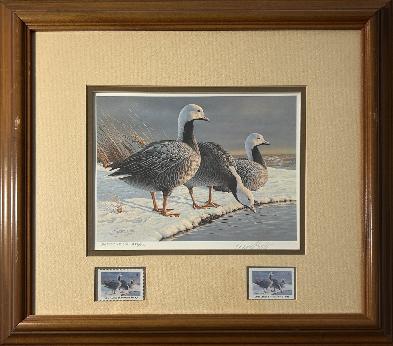 1985 ALASKA WATERFOWL CONSERVATION STAMP & PRINT BY DANIEL SMITH: Limited edition featuring three geese standing near the water's edge in a snowy landscape. Print numbered upon the lower left and signed upon the lower right by the artist in pencil. Two stamps presen