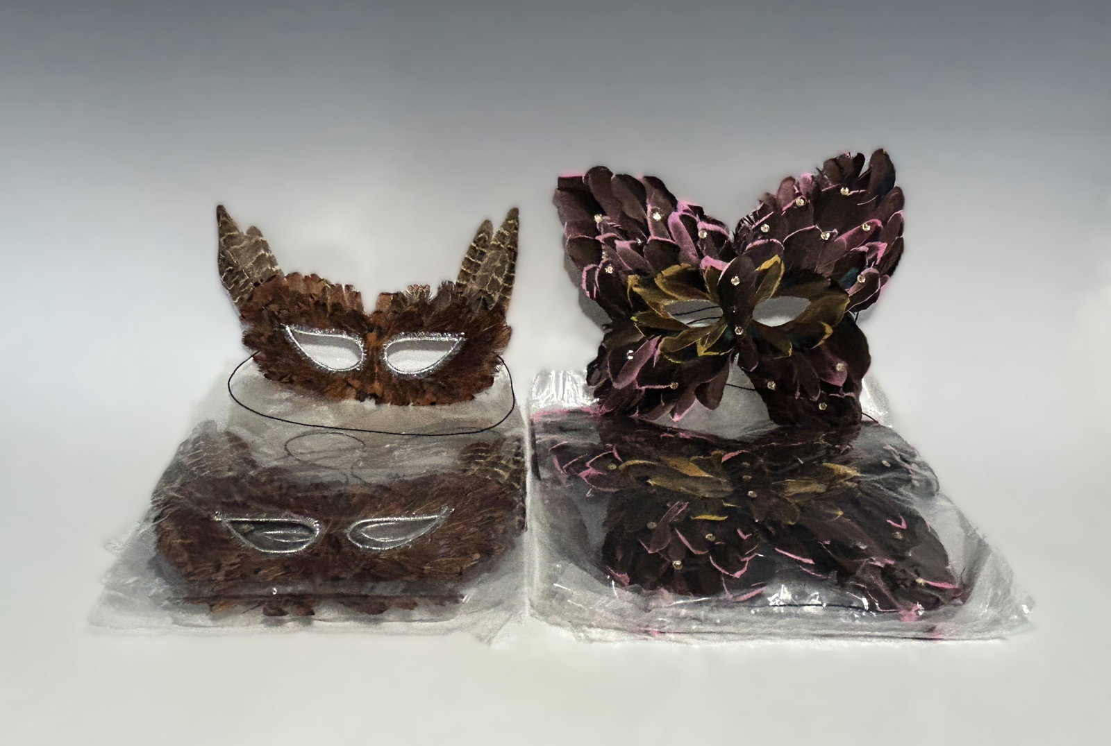 VINTAGE OWL AND BUTTERFLY FEATHERED MASQUERADES, TWELVE EACH KINDS: A complete event or boutique-level inventory of high-quality costume accessories, including 12 owl feather eye masks featuring layered, naturally patterned brown and speckled feathers arranged to mimi