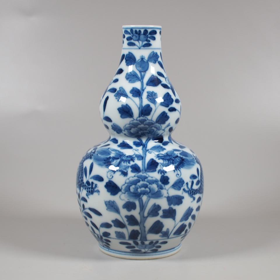 A Chinese blue and white porcelain gourd vase: A Chinese blue and white porcelain gourd vase decorated with dragons and flowers, late 19th century. 4 character mark to base. Height 18 cm