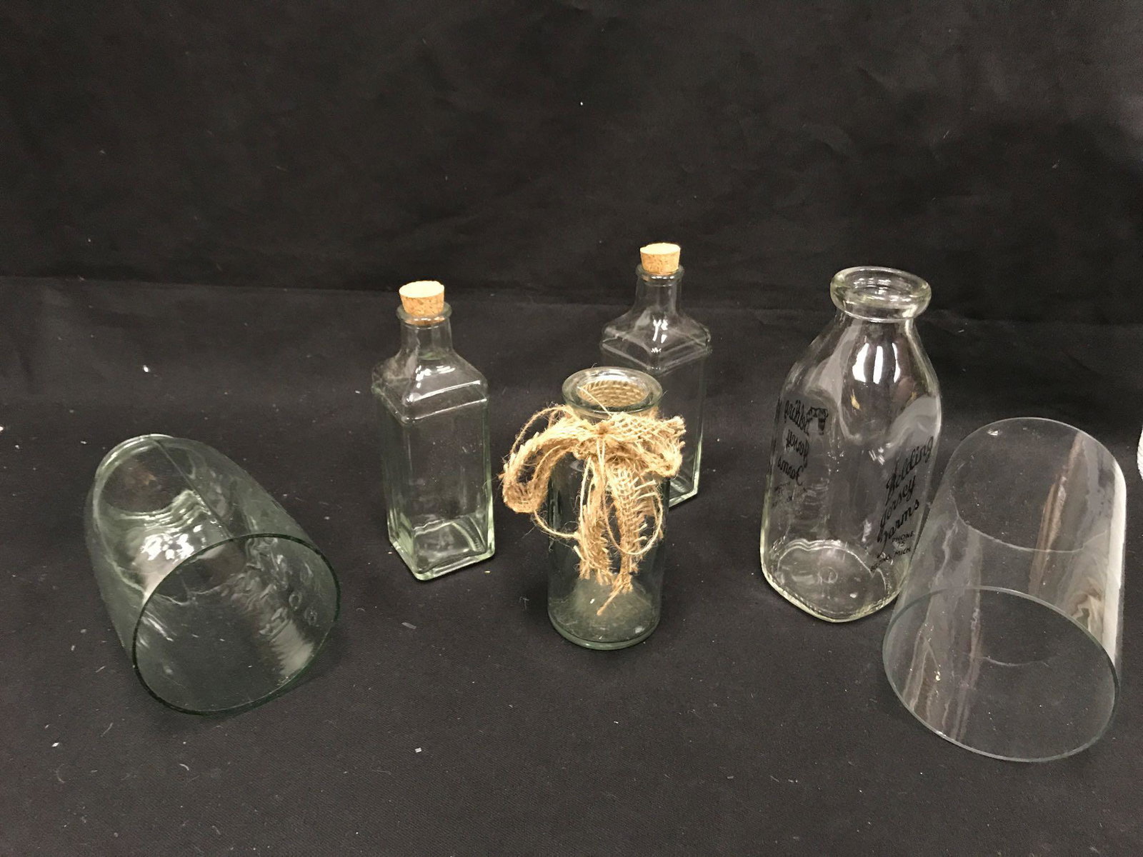 Glass Bottles: Four glass bottles and two glass chimneys Approximately 10” tall All items pictured