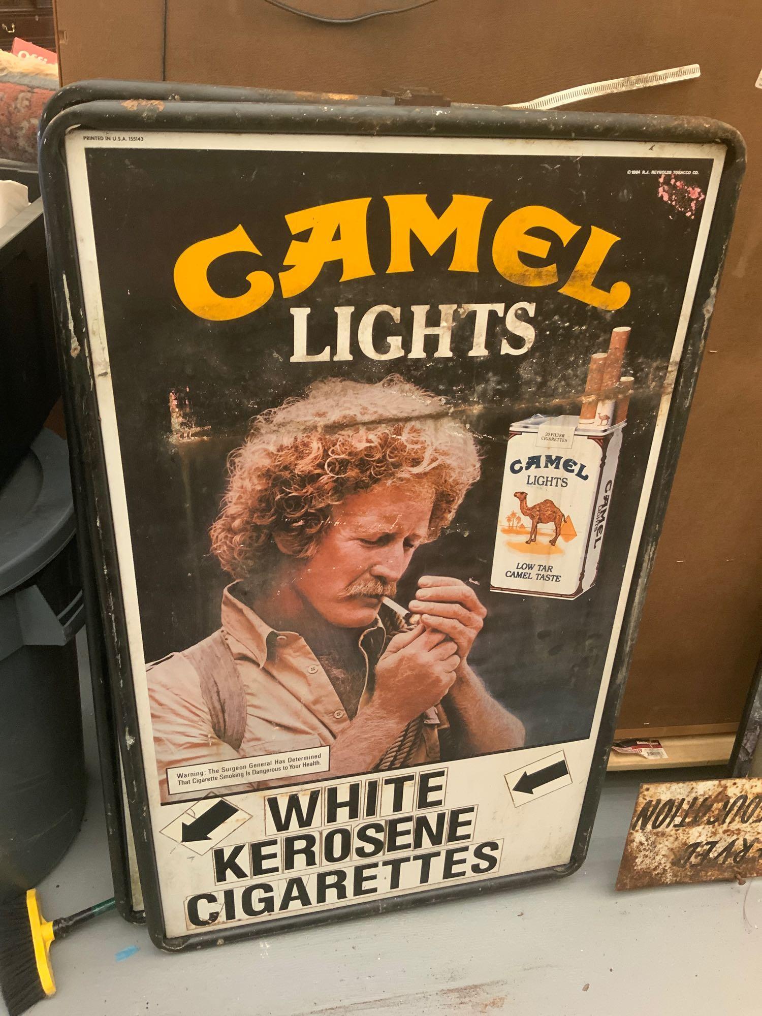 Metal camel lights signed by RJ Reynolds: Metal camel lights sign with holder house date 1984 RJ Reynolds tobacco company with white kerosene arrows and cigarettes at bass two signs one money, 4 feet by 2.5 feet with holder