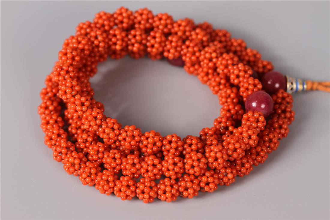 A STRING OF RICE BEAD SHAPED CORAL BUDDHA BEADS (1 of 7)