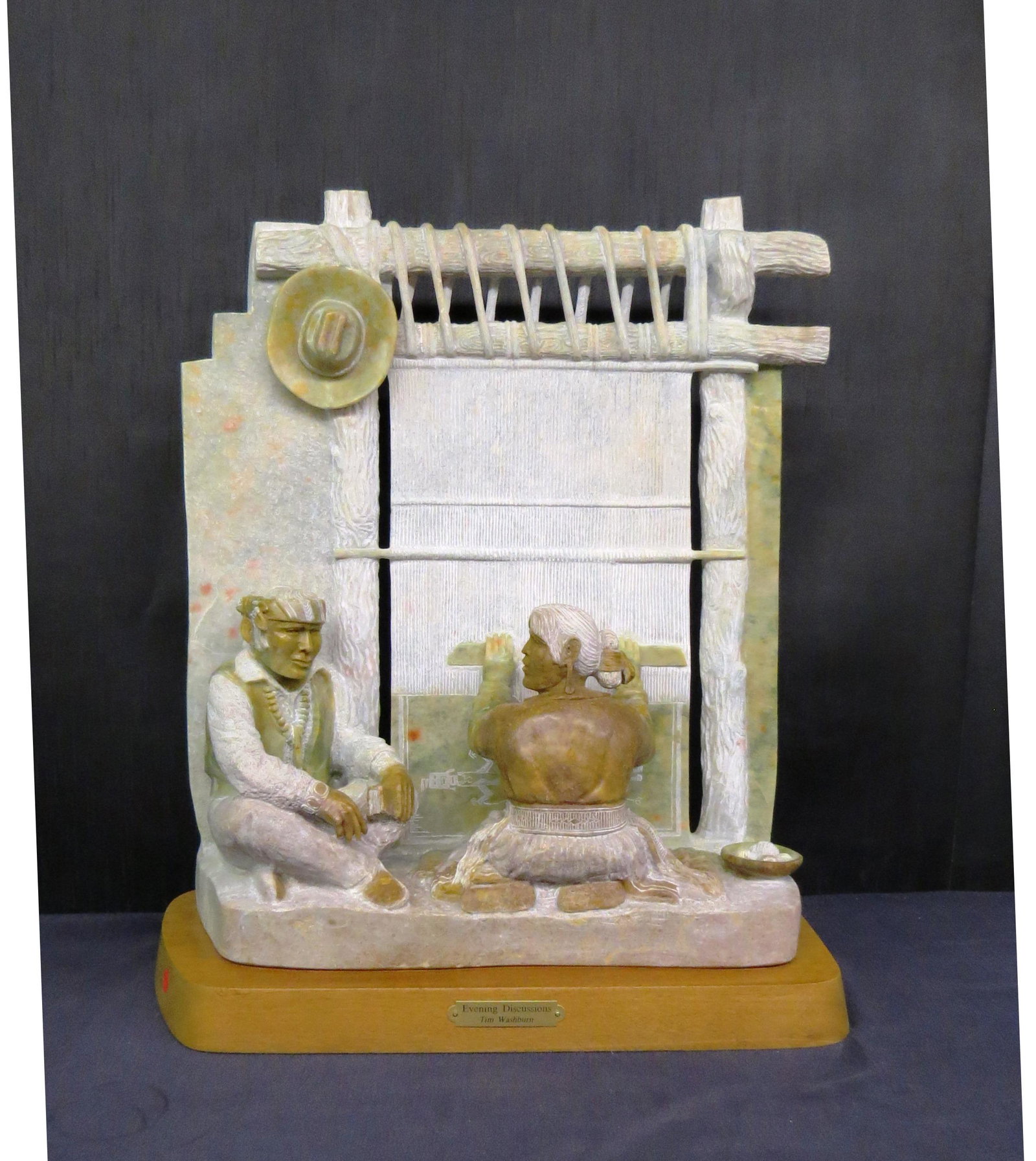 stone sculpture: Carved alabaster sculpture signed and dated Tim Washburn, 2005, titled "Evening Discussions" brown and green dominant colors, mounted on mahogany base 22w x 10" deep x 2" h. stone sculpture stands 26"