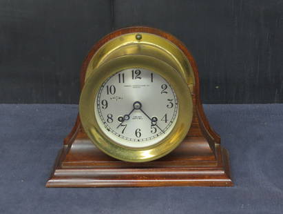 Chelsea ships clock: Chelsea ships clock on mahogany holder, 5 ½” bezel diameter, 7 ¼” h. in case, running condition, with key