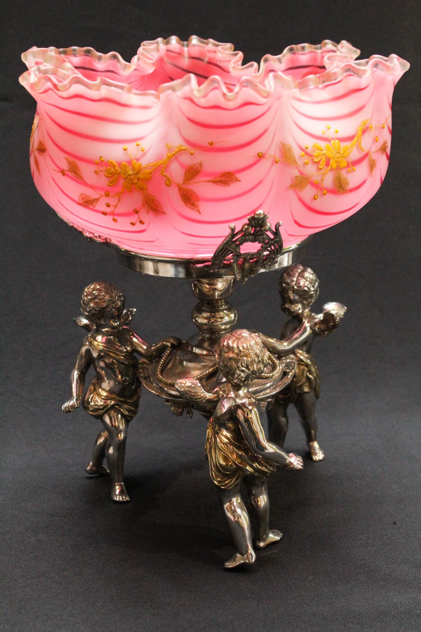 Fabulous Cranberry Nailsea Cherub Silverplate: An absolutely fabulous Cranberry satin Nailsea Glass gilt decorated Brides bowl centerpiece. Bowl is set in a wonderful Triple dancing cherub holder. Holder is signed and numbered. Bowl is fantastic. 
