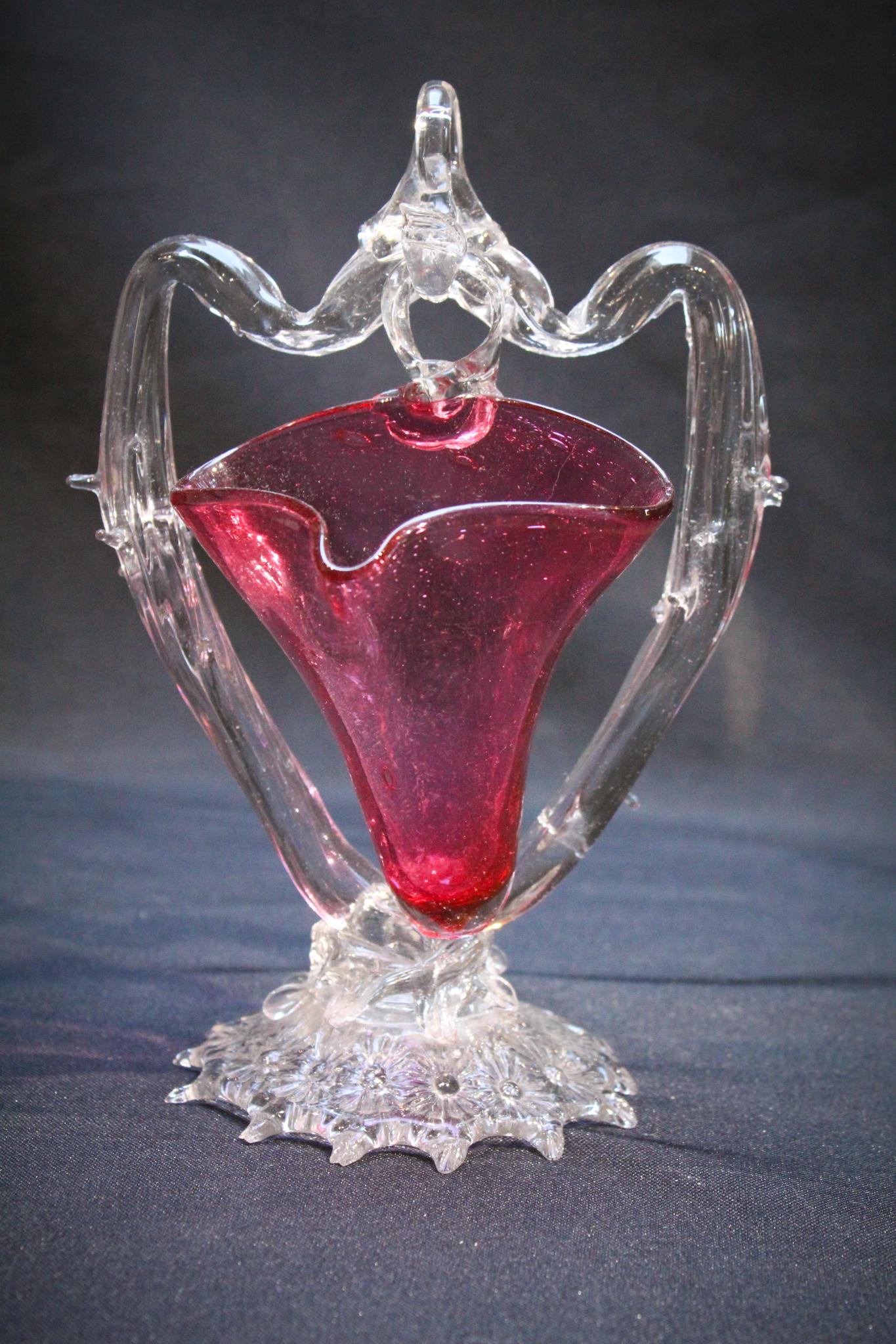 Victorian Cranberry Glass Hanging Vase Whimsy: So Nice! A cranberry Victorian glass hanging whimsy. Stand is thorny detailed. Hanging vase is rich deep cranberry coloring. Measures: 8" tall, 5" wide. Condition: Excellent