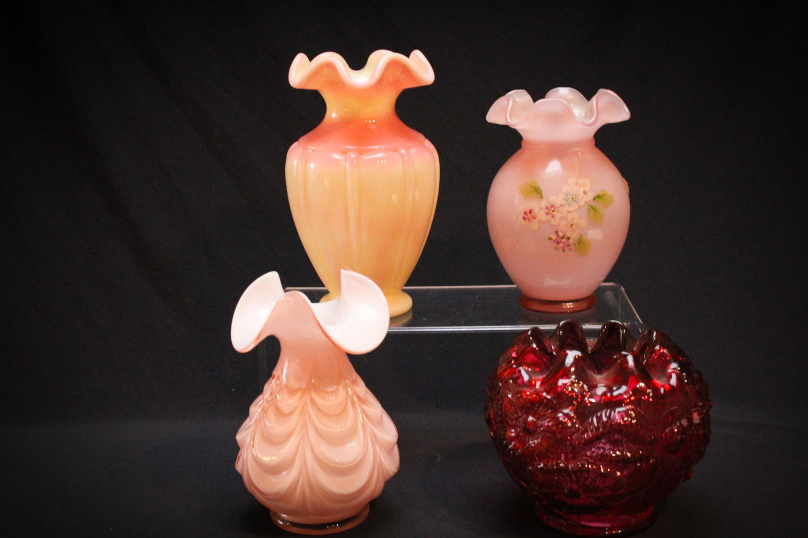 4pc Lot Fenton Glass Vases: Lot of 4 pieces of Fenton Glass vases to be comprised of pink cased, cranberry, and burmese. Tallest measures 6 3/4"