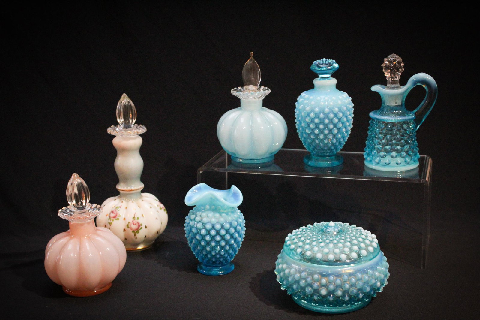 7 pc Lot Fenton Glass Vanity Items: Lot of 7 pieces of Fenton Glass Vanity items to include blue hobnail, etc. examples. Tallest measures 7" tall.