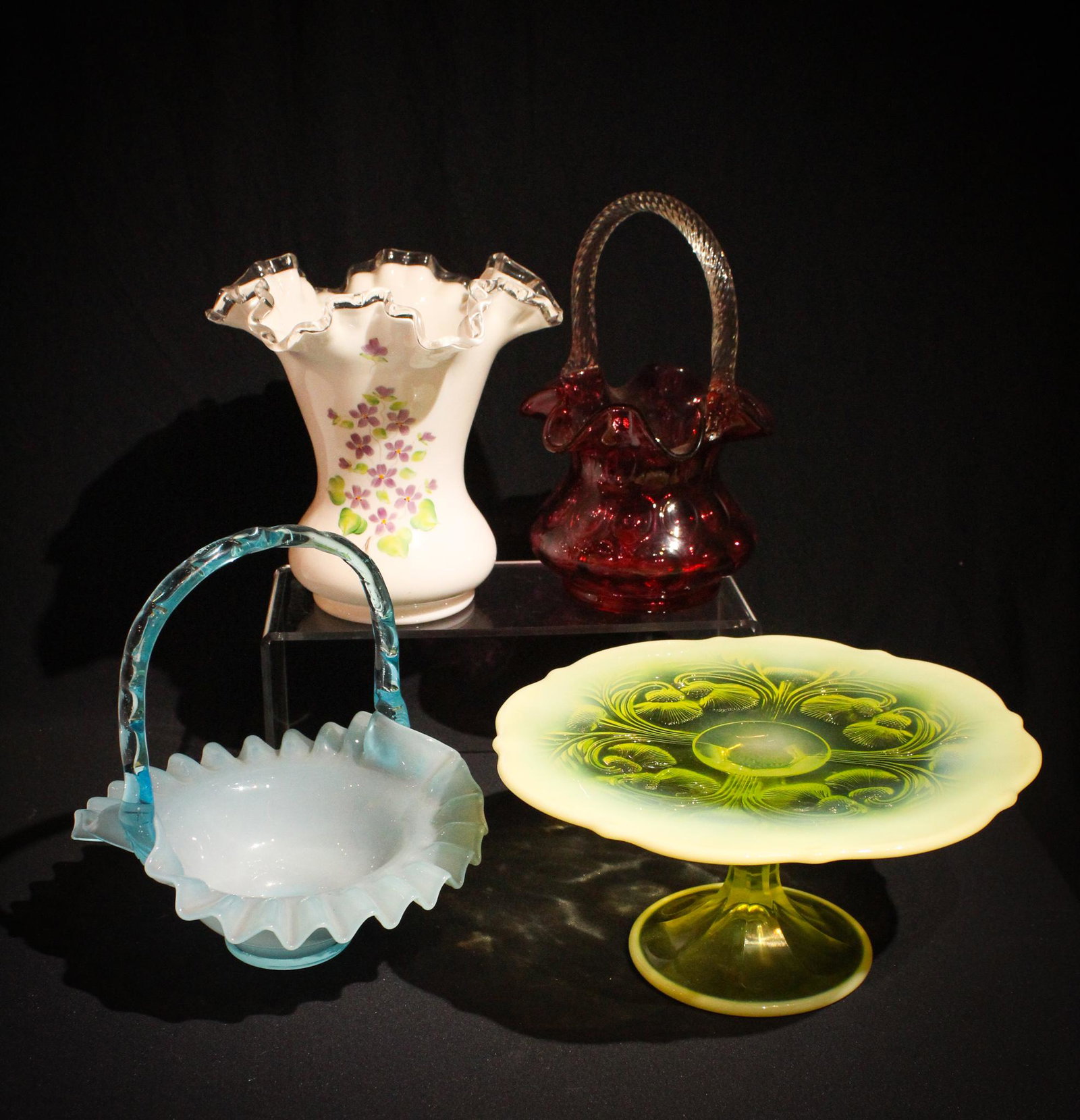 4 pc Lot Fenton & Mosser Glass: A 4 piece lot of Fenton and Mosser glass comprised of 2 baskets, a vase, and a cakestand. You get a lot for your money on this one folks. Evrything you always needed to carry something, to put flowers