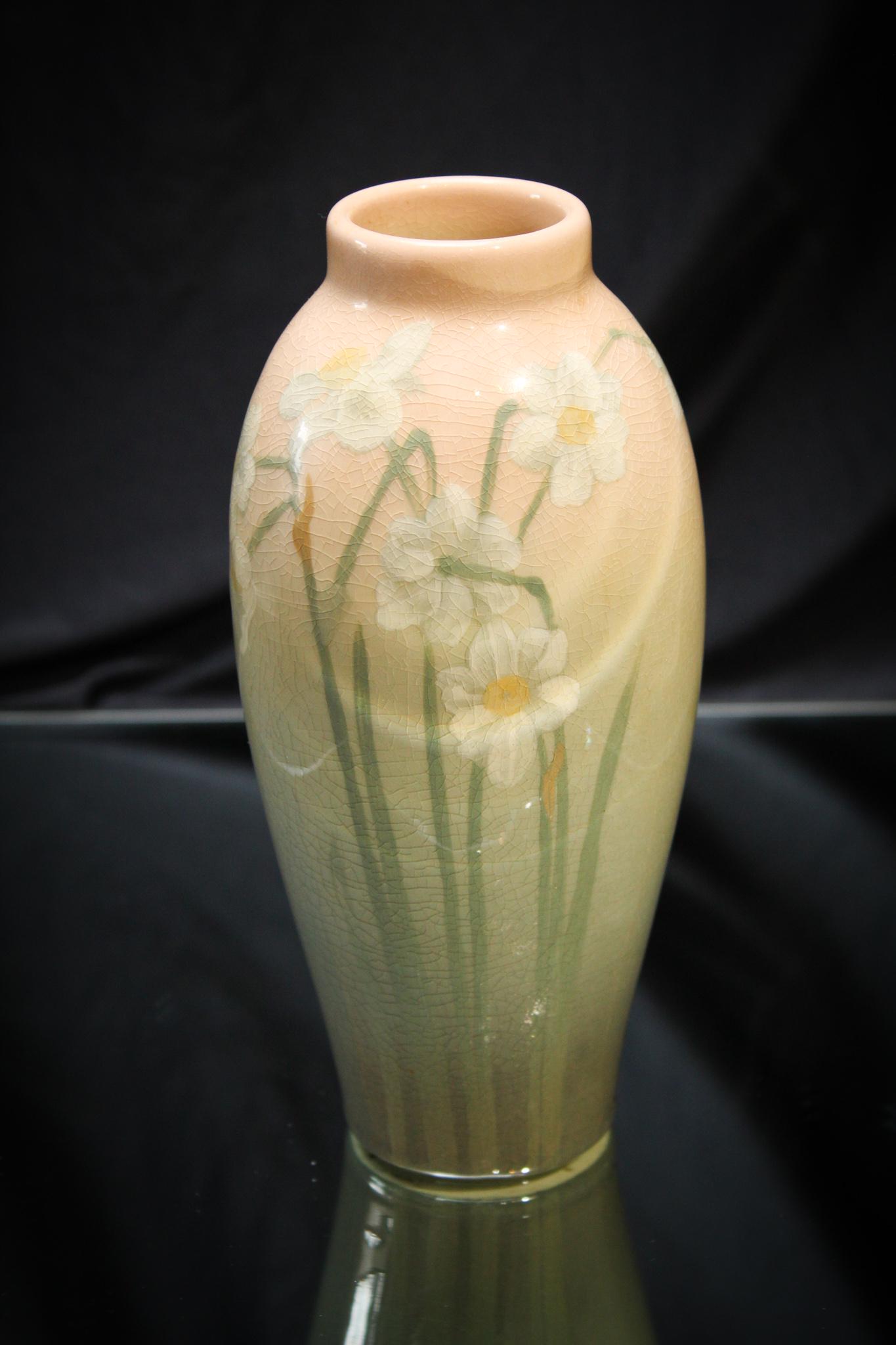 Rookwood Pottery Narcissus Vase: A signed Rookwood pottery vase with narcissus dÃ©cor. Lovely depiction of the spring flowers. Typical crazing as shown. Measures 7 1/4" tall.