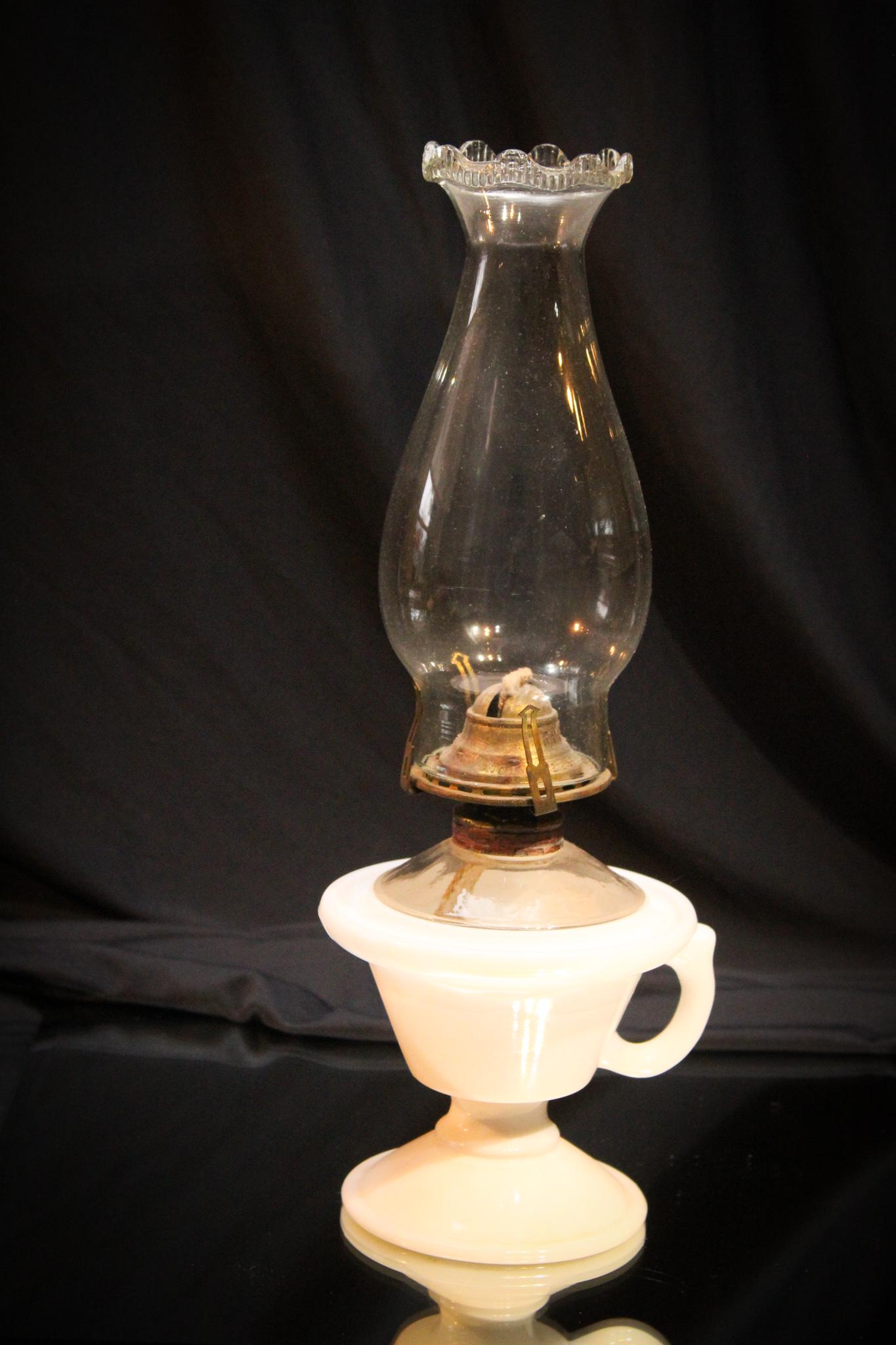 Milk Glass Saucer Victorian Finger Oil Lamp: Boy this is unusual. Take a look again. Milk glass saucer base finger oil lamp with clear top of font. Great early lamp. Measures 5" tall to the top of the burner collar and 13" to the top of the chim