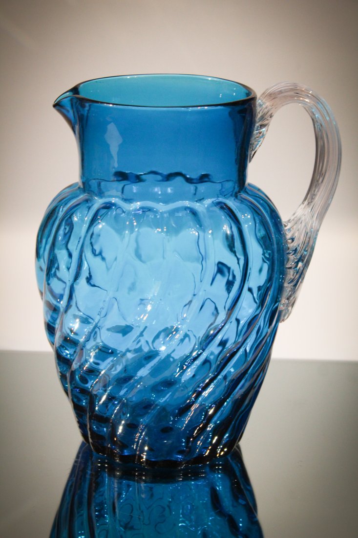 Celestial Blue Victorian Swirl Mold Pitcher: This is a big pitcher folks. Attributed to Phoenix glass, this swirl mold with inverted thumbprint pattern can hold a lot! Deep celestial blue with clear applied reeded handle. Measures 9" tall.