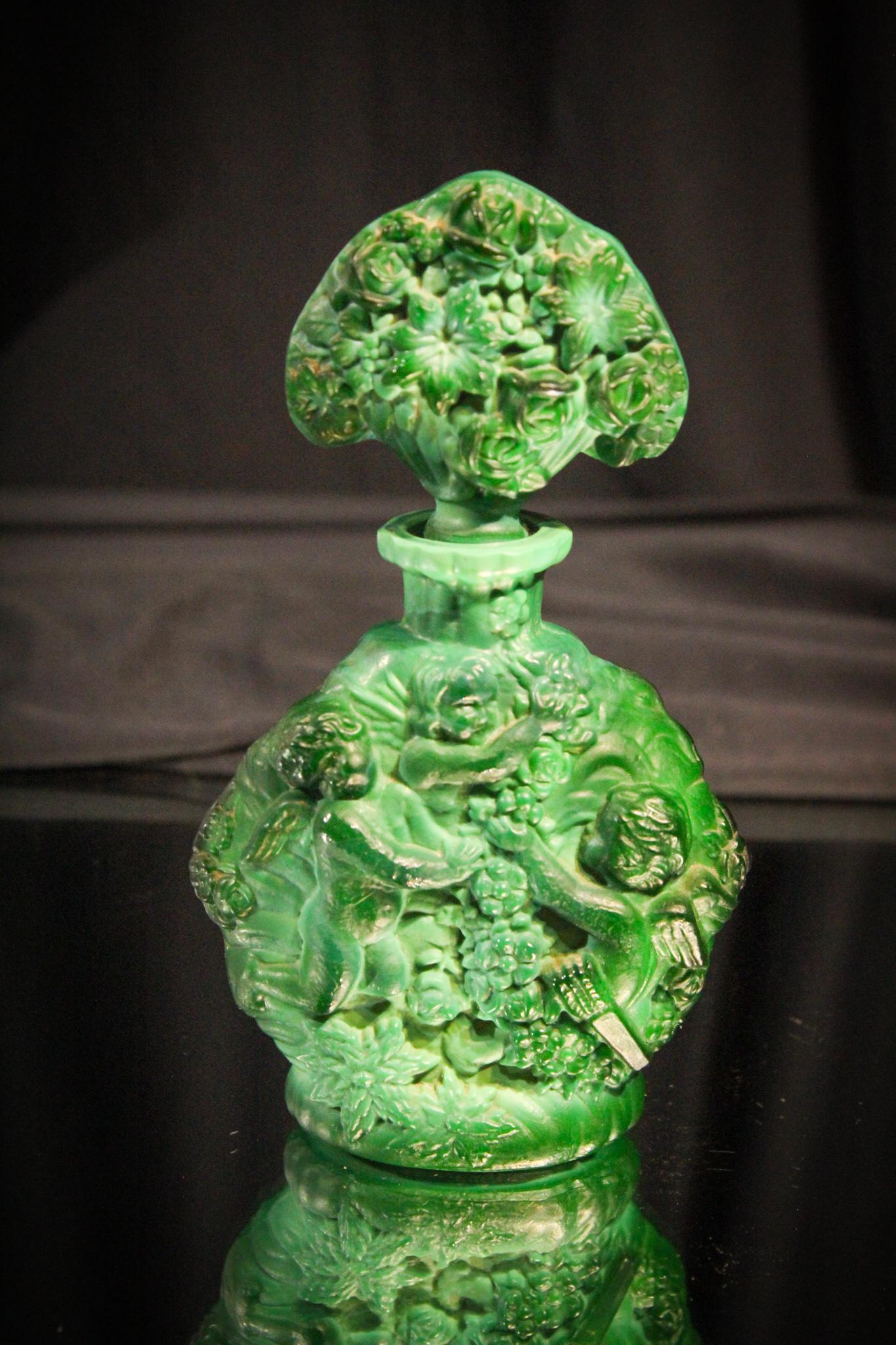 Art Deco Malachite Glass Cherub Perfume: We love green and this malachite glass is no exception. Beautiful deep green variagated coloring. This perfume is embossed with a cherub. Matching original stopper. Measures 6 1/2" tall.