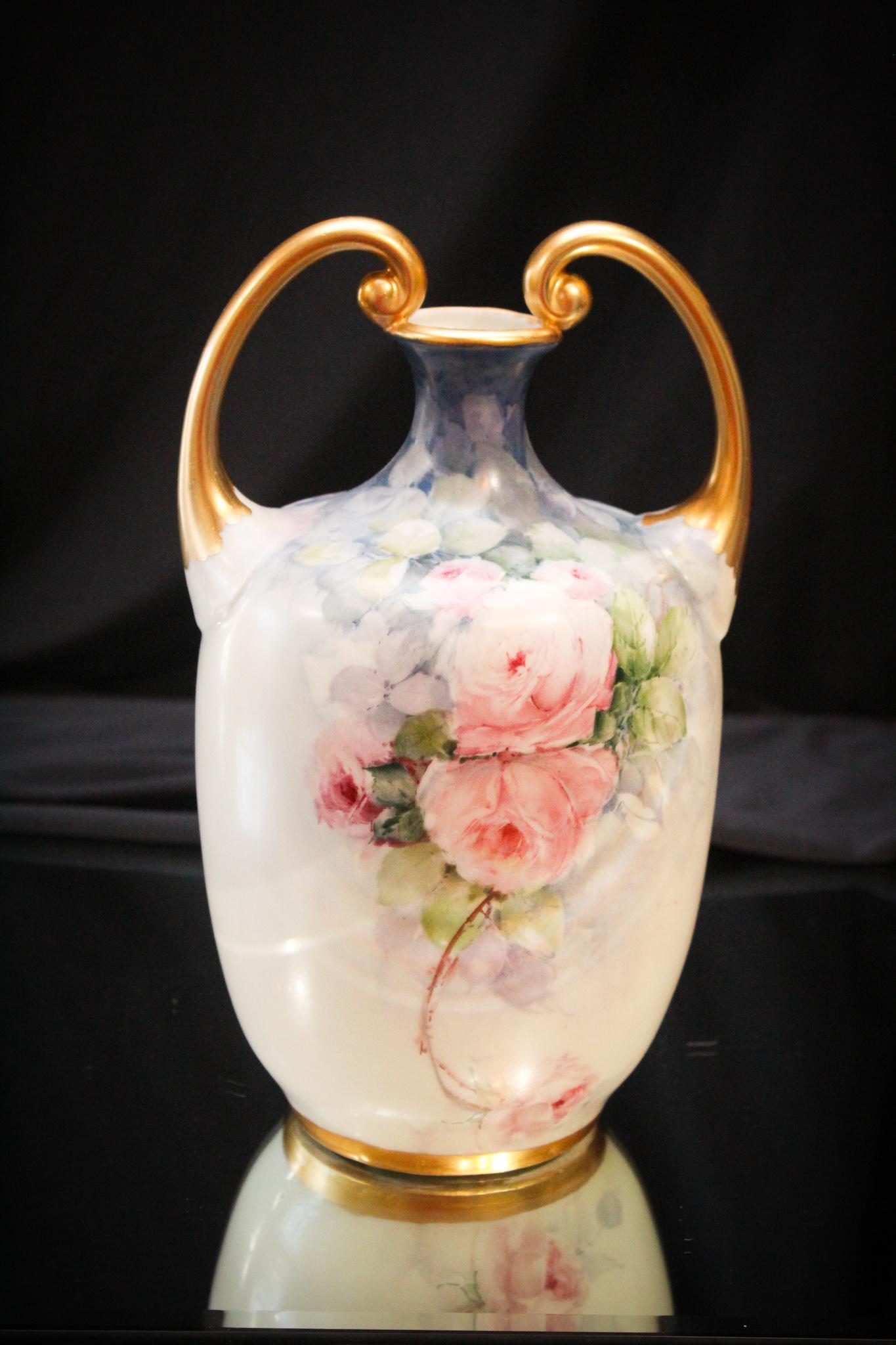 Royal Rudolstadt HP 10" Rose Decor Vase: What a grand piece this is. Roses cover this stunning vase and it's also embellished with lots of gold. On the twin handles. Mesures 10" tall.