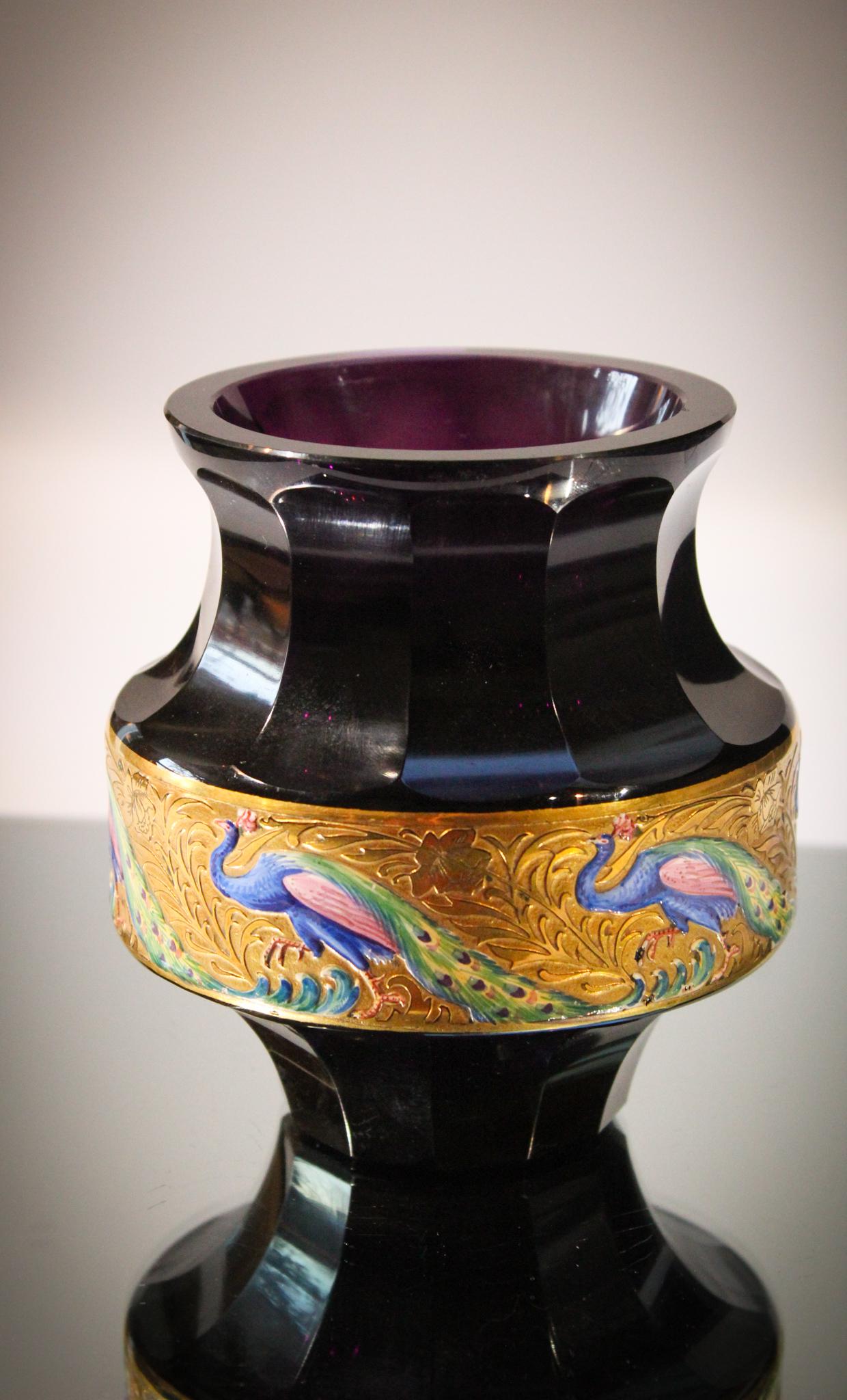 Moser Amythest Glass Peacock Vase: Deep deep rich amythest glass attributedd to Moser Karlsbad is cut faceted with a gilt and enameled band of proud peacocks. Most unusual dÃ©cor for this type of piece. The peacocks are brilliantly c