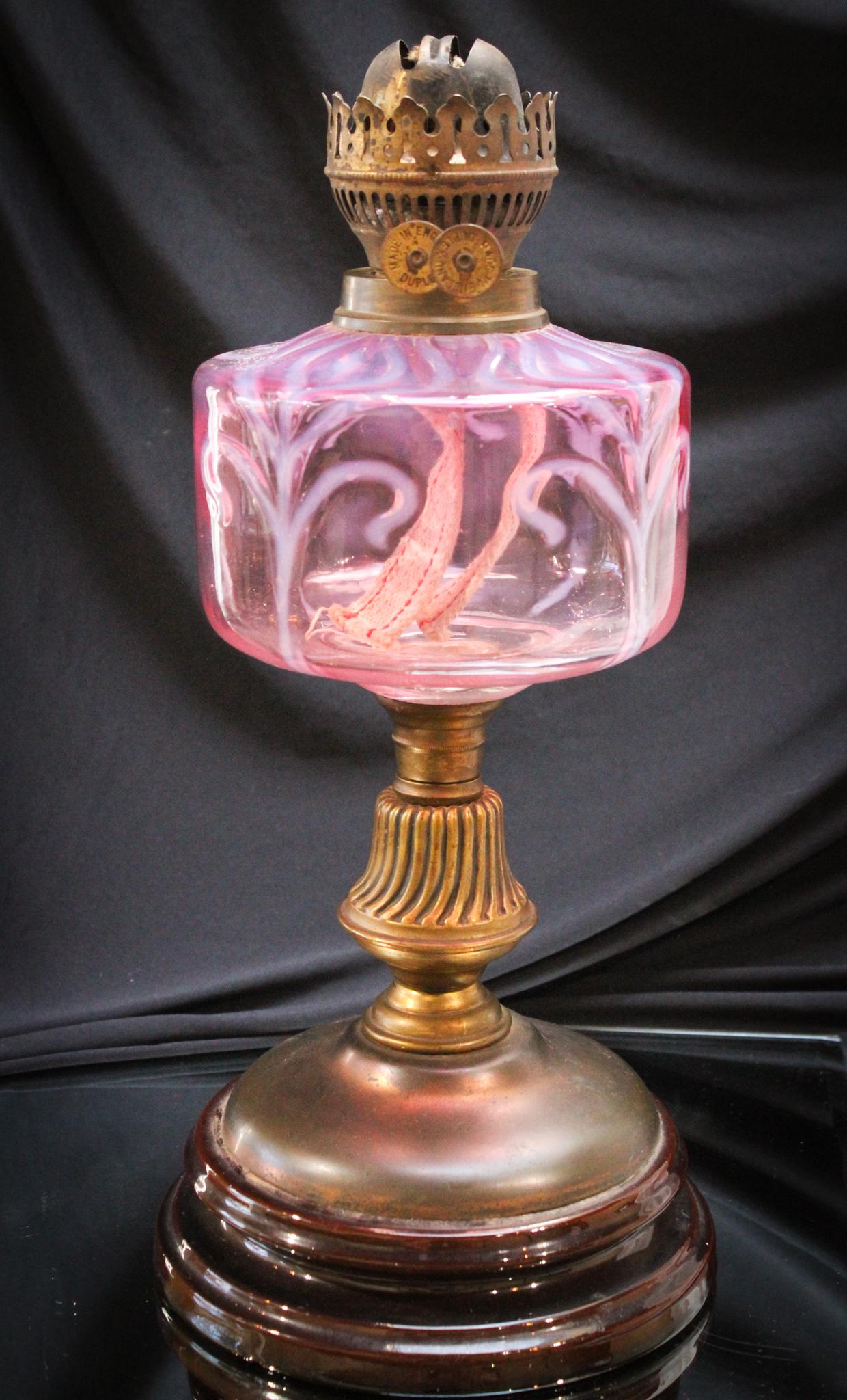 Cranberry Opalescent English Victorian Oil Lamp: Quite a find here. Great all original & as found in the estate, cranberry opalescent Victorian oil lamp. Interesting pattern to the opalescence. Most definitely rare. Nice old burner. Measures 15 3/4"
