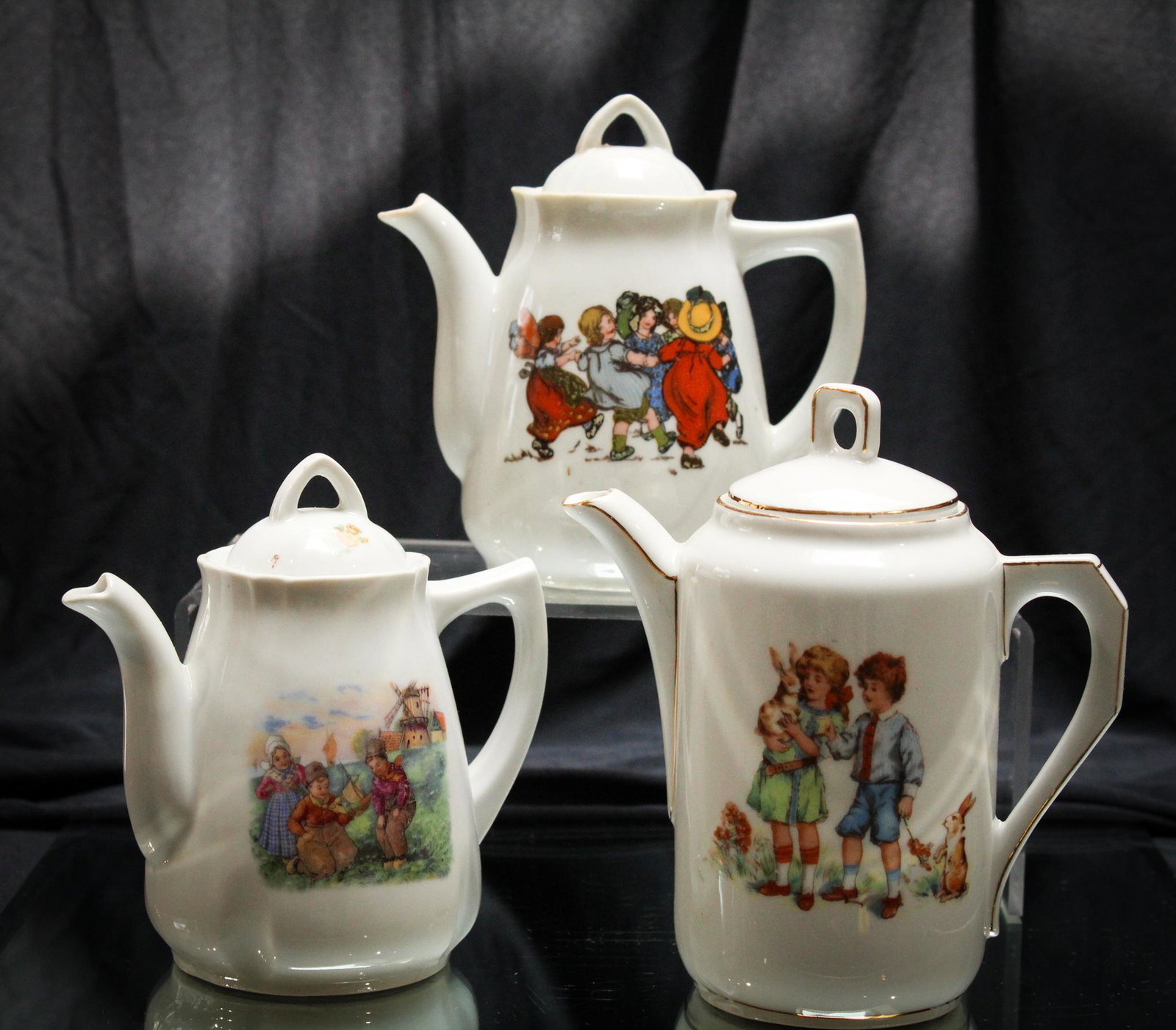 Victorian 3 pc Lot Child's Tea Pots: What another nice offering here of 3 assorted child's tea pots. Such cuties with children and scenic dÃ©cor. Tallest measures 6" high.
