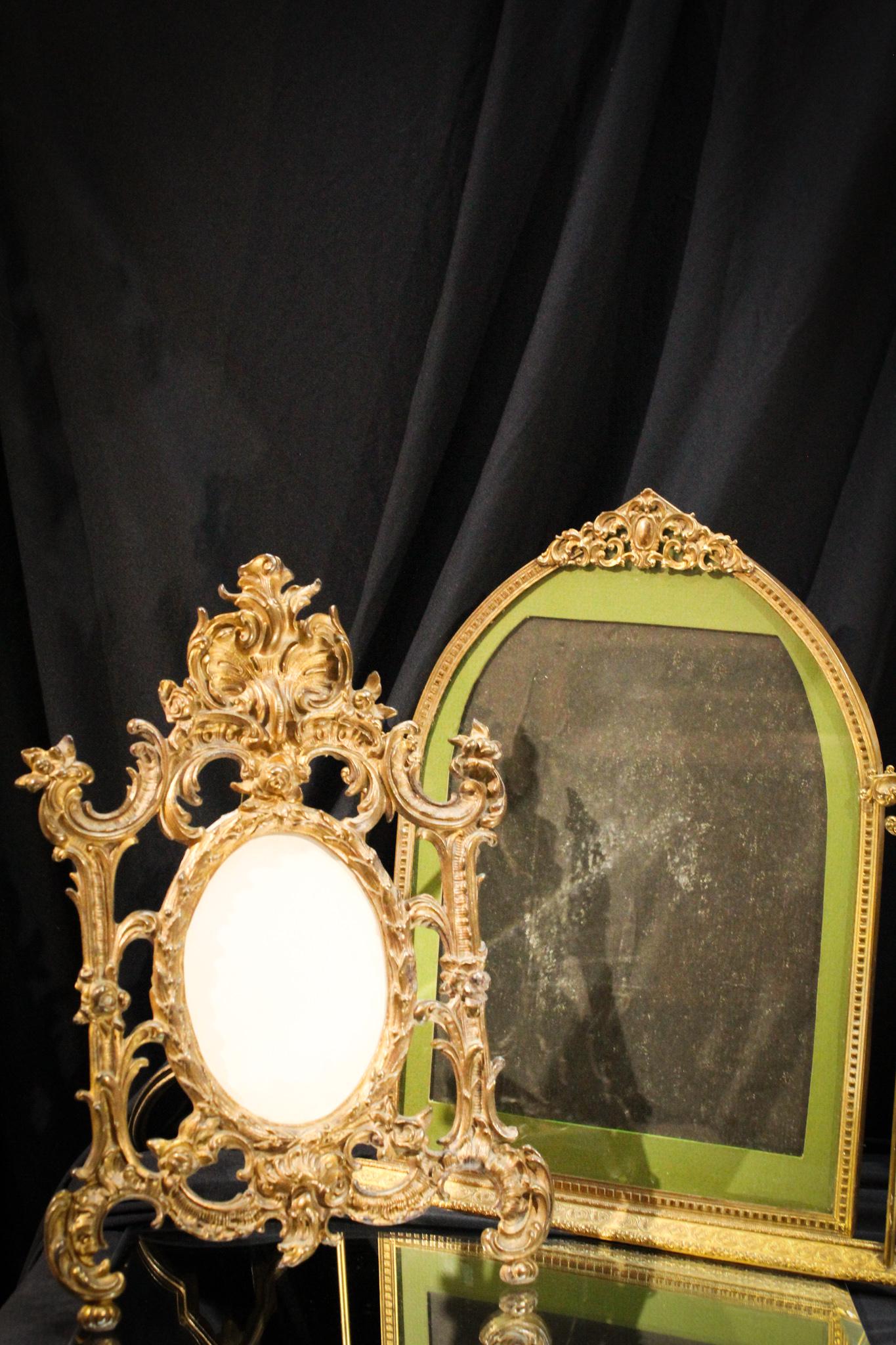 Pair of Antique Brass and Art Deco Picture Frames: Lot of 2 antique picture frames, one of Victorian cast brass, and the other being a wood Art Deco period example. Largest measures 14" tall.