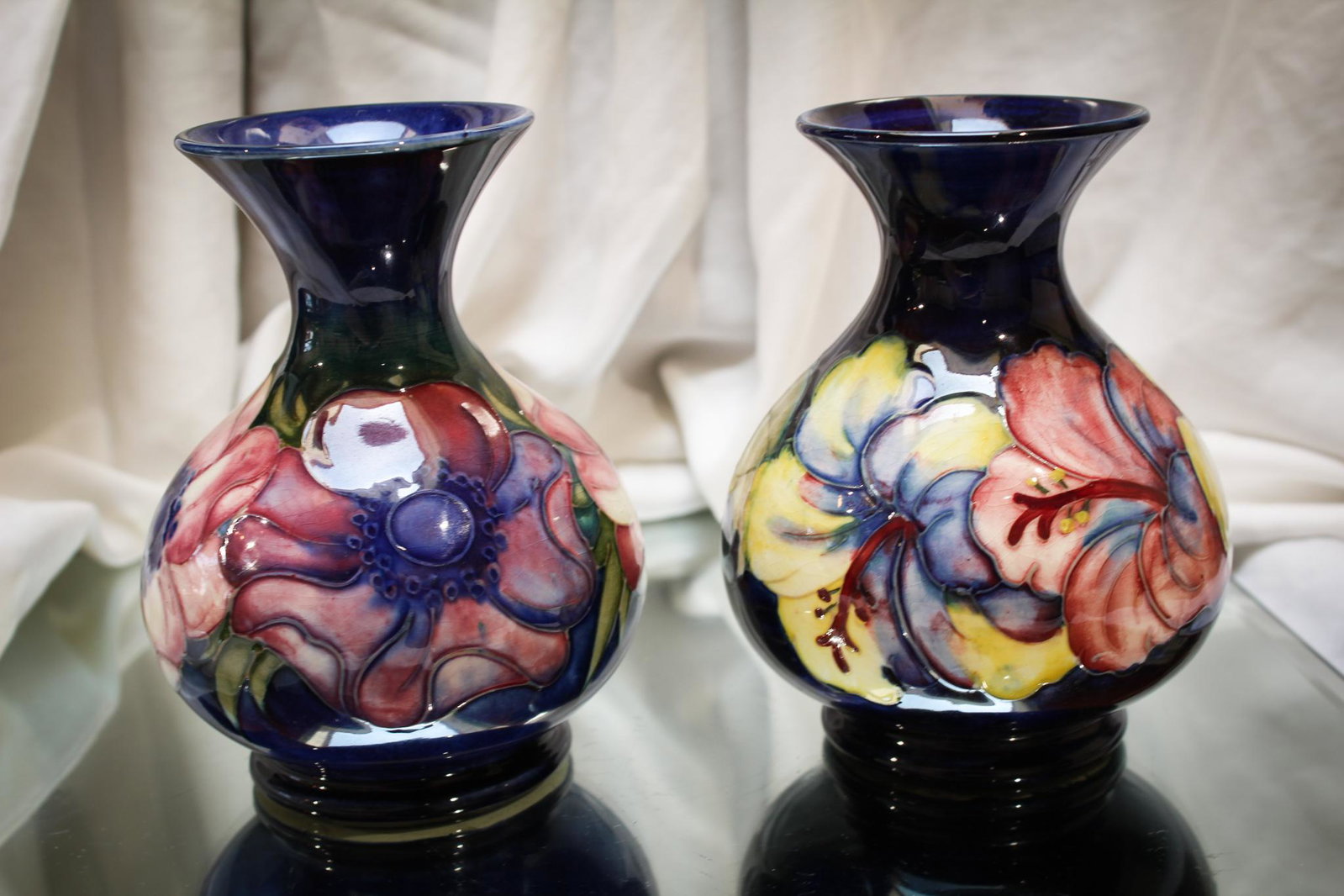 Pair of Moorcroft Pottery Floral Vases: Always nice to have a pair of anything. These are no exception. Lovely pair of moorcroft pottery vases with floral motif dÃ©cor. Each measuring 5" tall.