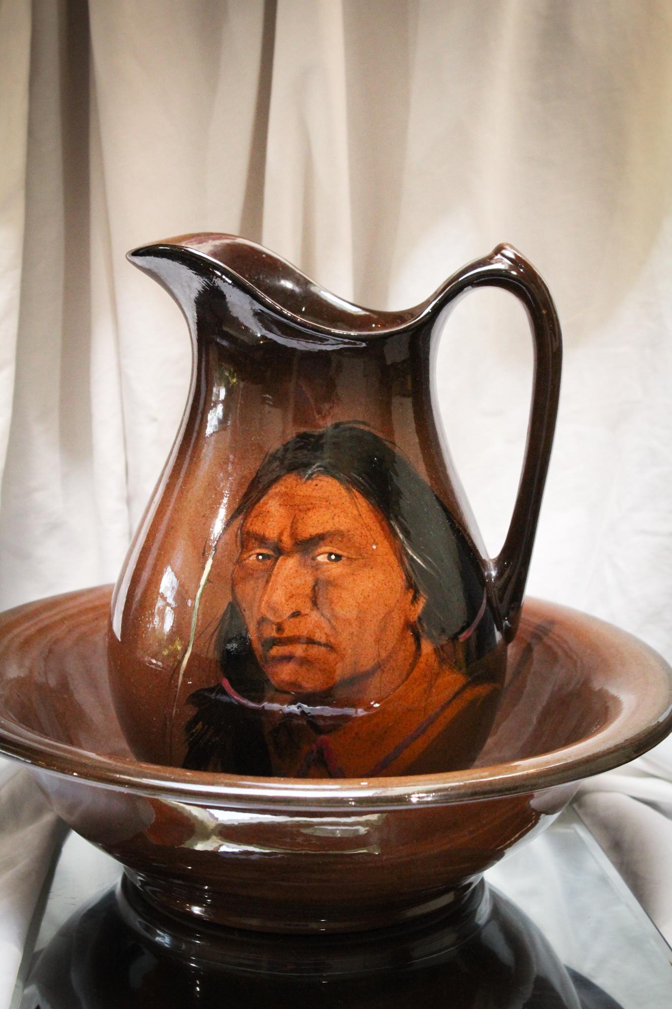 Rick Wisecarver Pottery Portrait Indian Native Pitcher & Bowl: Deep Hershey chocolate brown pitcher and bowl set with portrait Indian Native dÃ©cor. Only the somewhat-best coloring you may want in a Rick Wiscarver pottery piece. Indian has a stern, yet demure, 