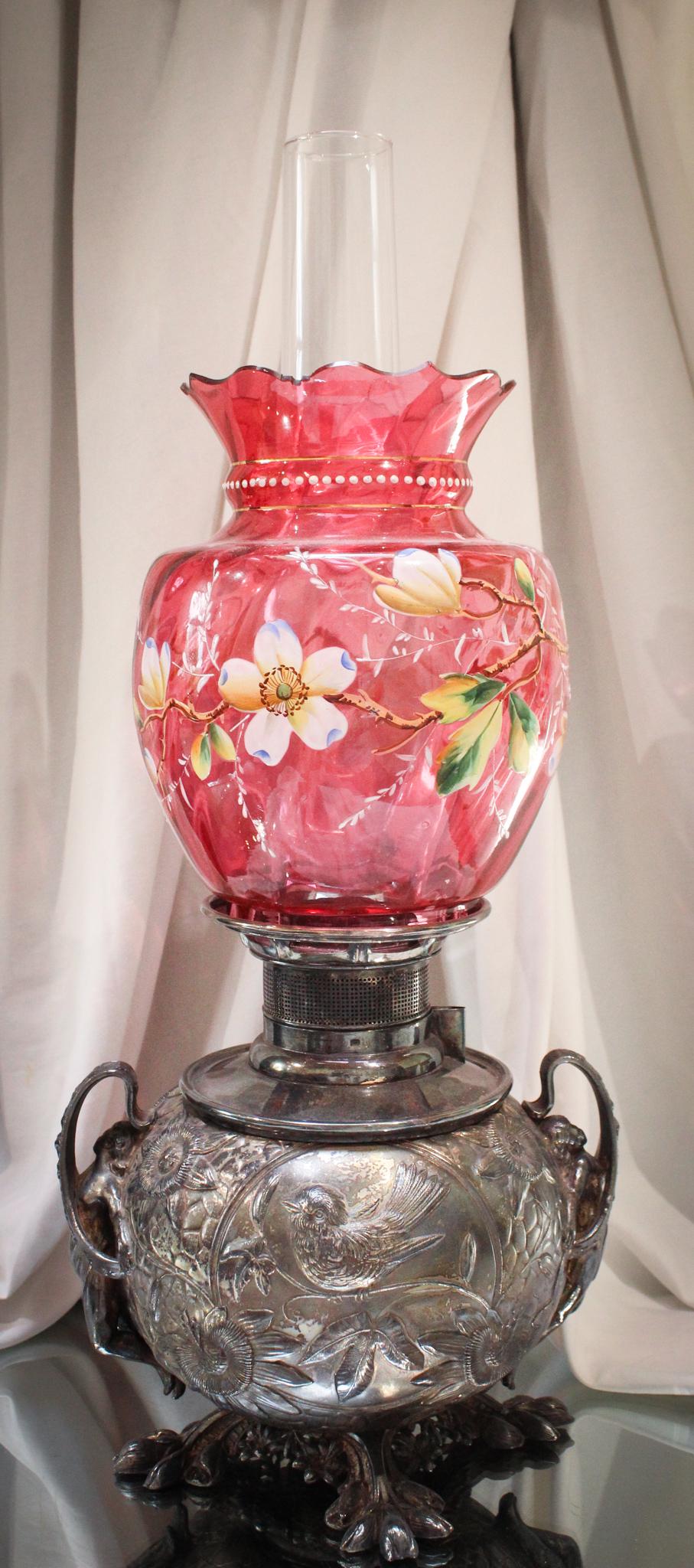 Fantastic Cranberry Enameled Silverplate Parlor Oil Lamp: Woza folks. This is beautiful! The amazing silverplate base is adorned with full figure female nudes, birds, and passion flowers. Shade is profusely decorated with enameled flowers. Cut top treatment 