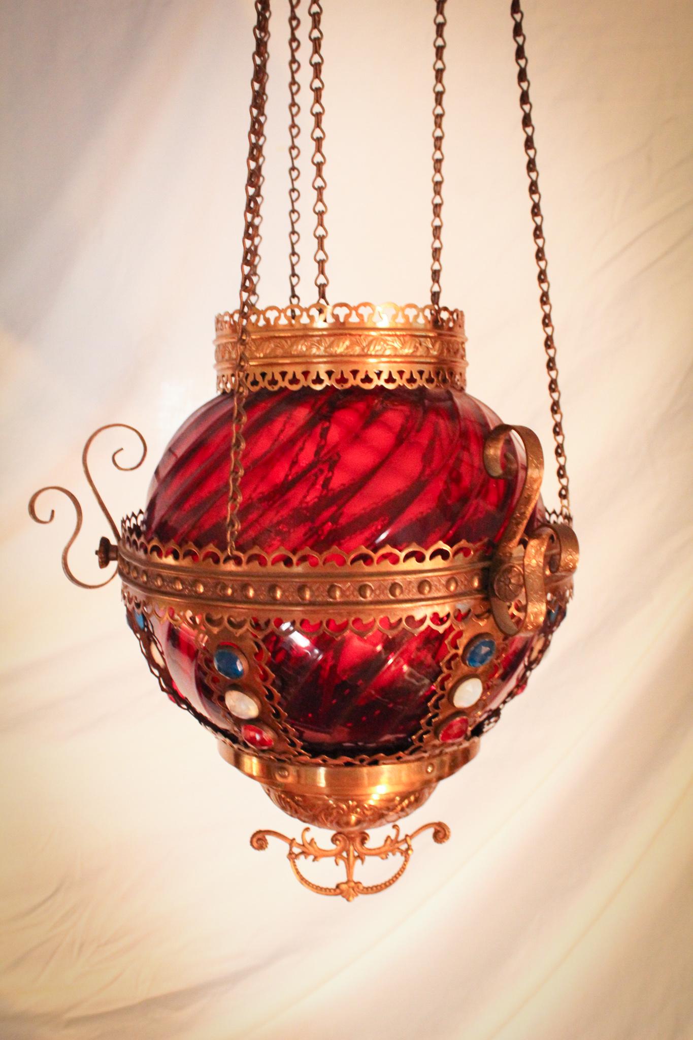 Victorian Jeweled Ruby Glass Hanging Hall Lamp: What a lovely one this is folks! Stunning ruby swirl patter glass shade nestled in an ornate frame bedazzled with jewels in the patriotic colors of red, white, and blue. Boy we could use a little patr